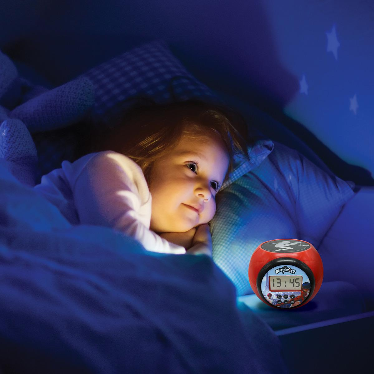 Un niño en la cama por la noche, mirando un despertador Miraculous que muestra 13:45, en una habitación oscura y azul.