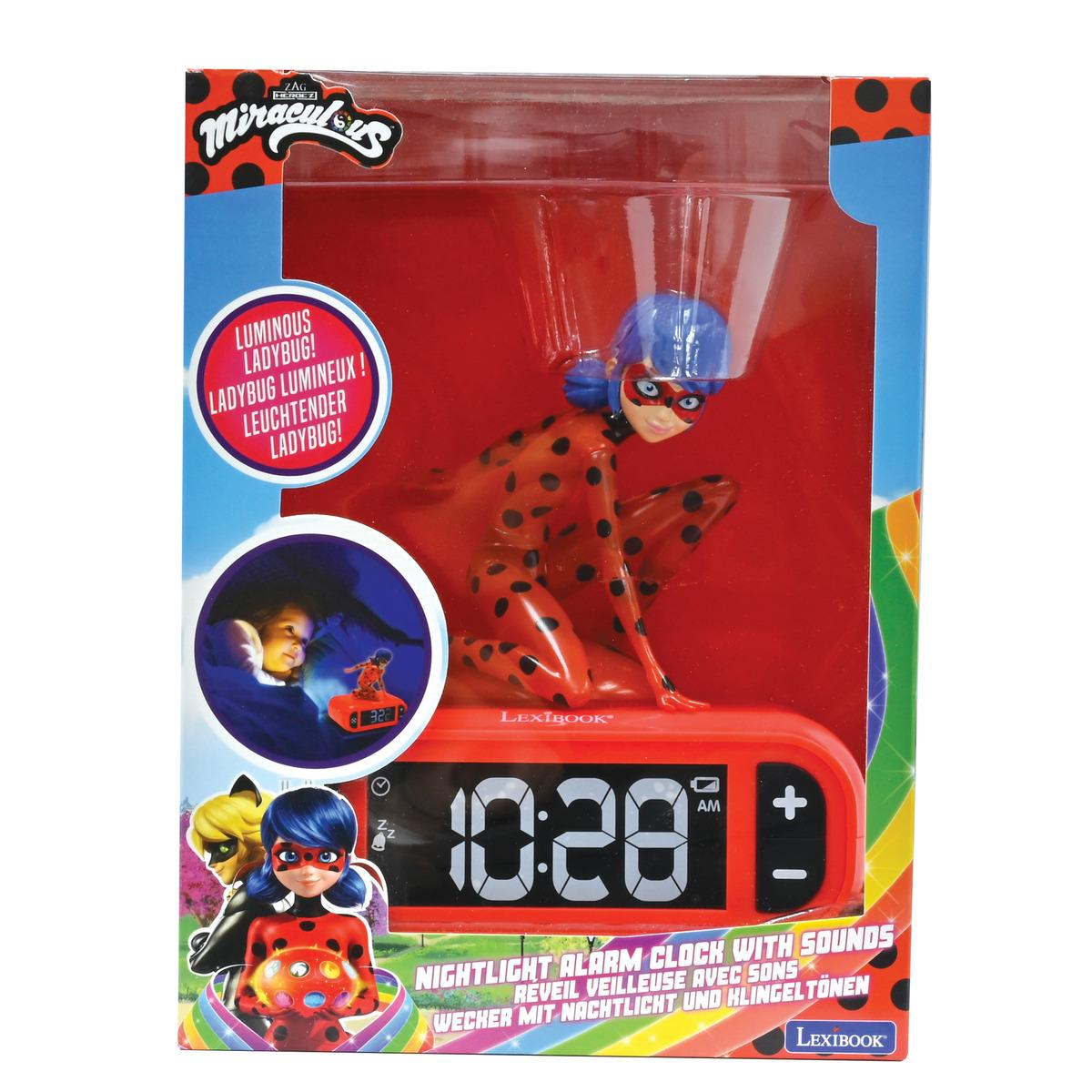 Despertador con una figura de Miraculous Ladybug. La esfera del reloj muestra las 10:28. Fondo blanco.