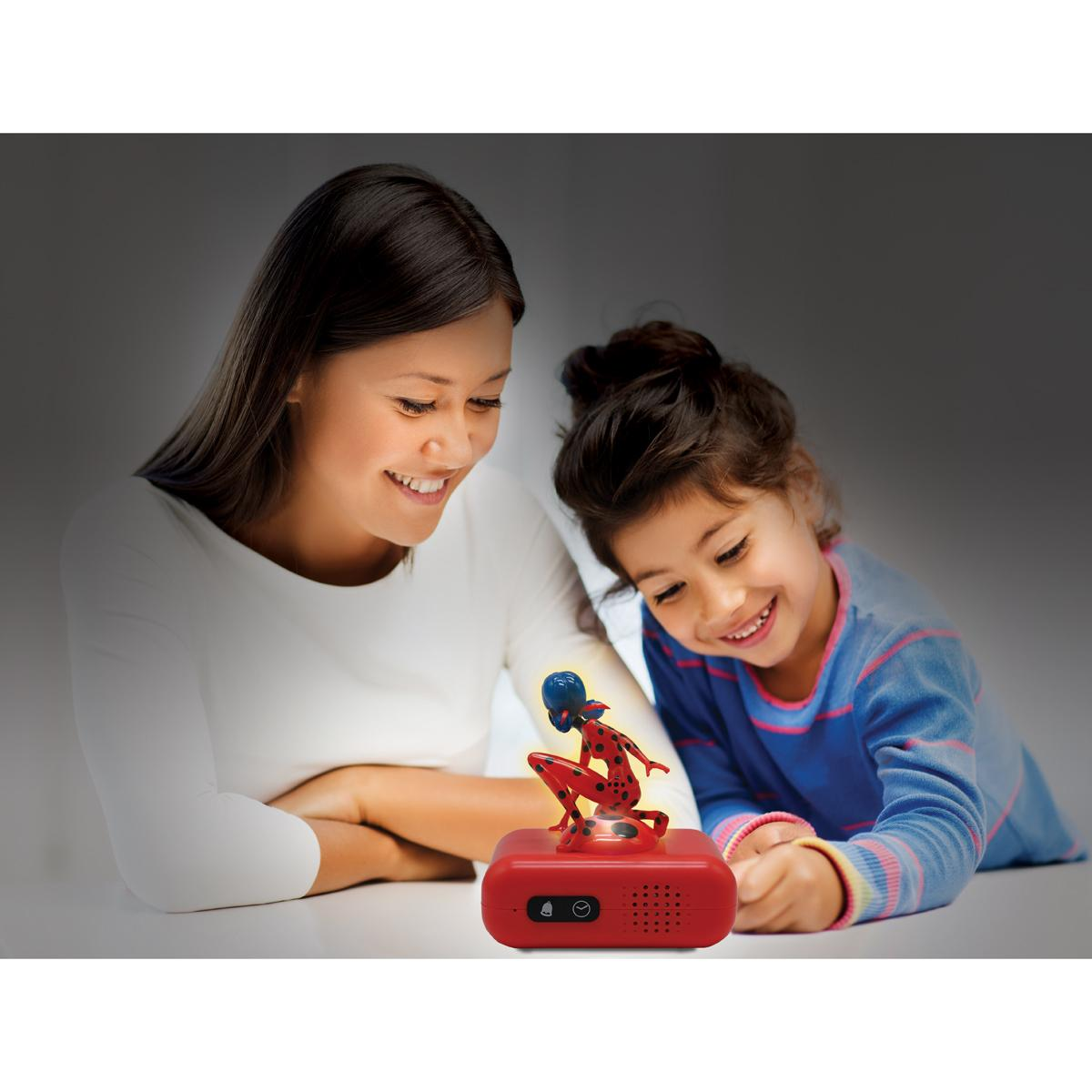 Mujer y niño mirando un objeto rojo. El objeto es una figura roja sobre una base roja. El fondo es oscuro.