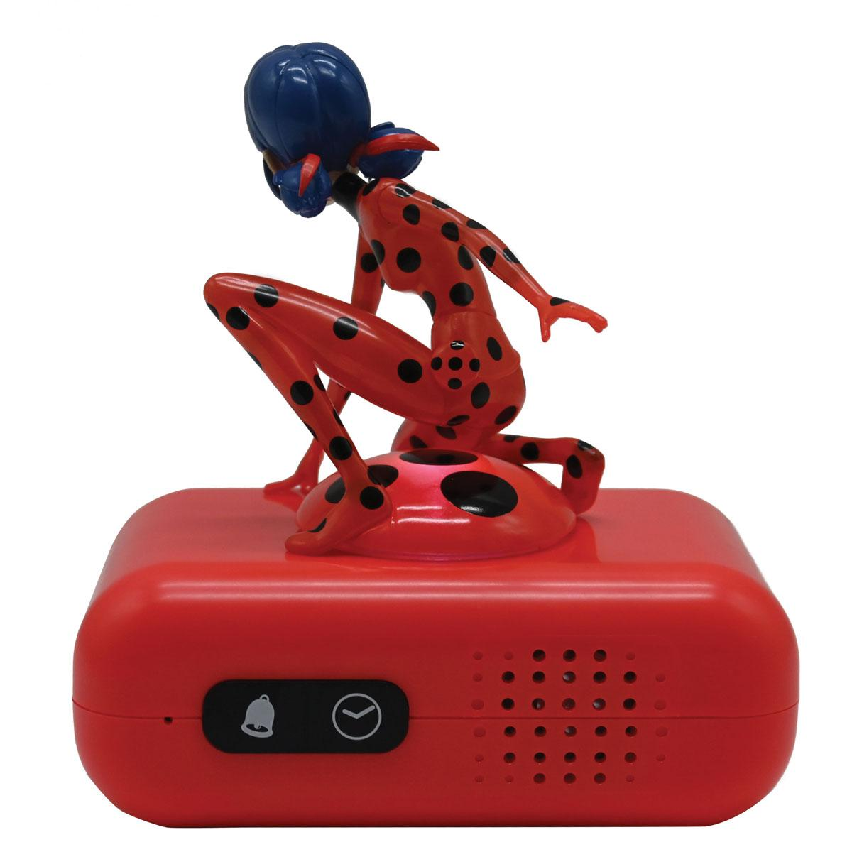 Figura de mariquita en un despertador rojo.