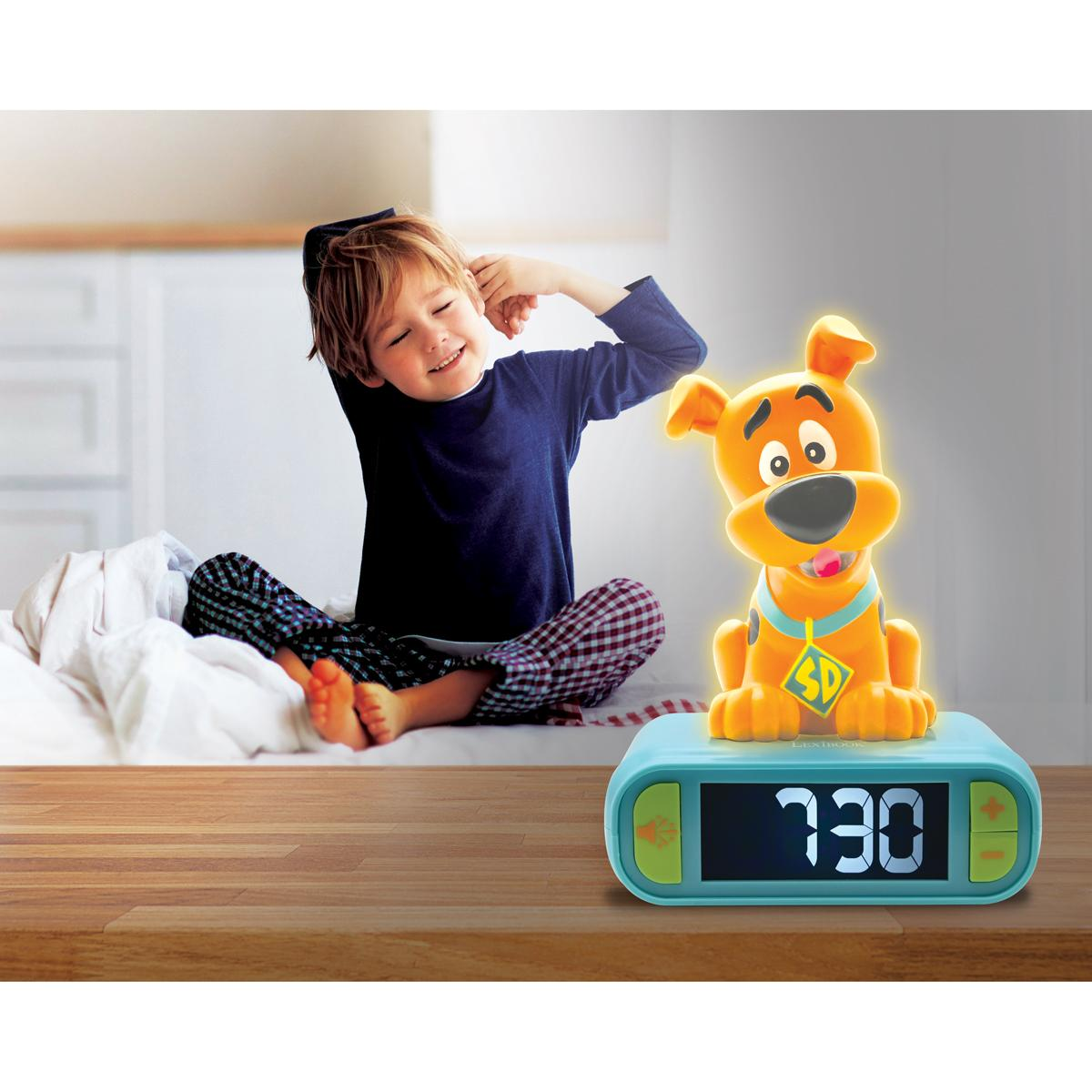 Junge dehnt sich neben einem Scooby-Doo-Wecker.