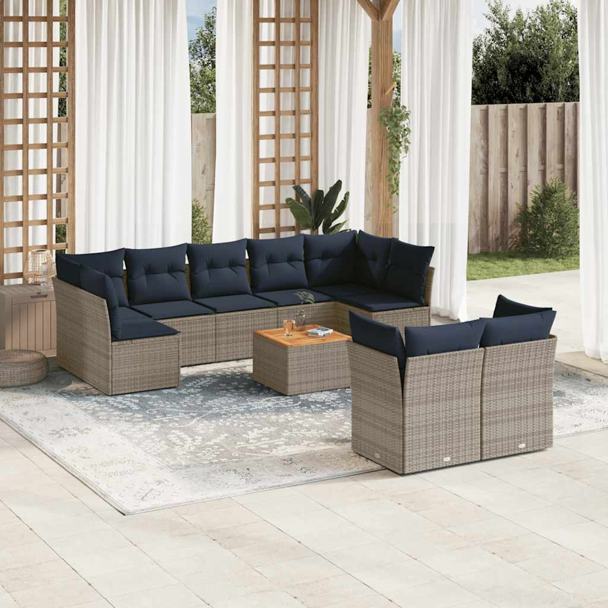 Set patio esterno con divano componibile, tavolino e tappeto.