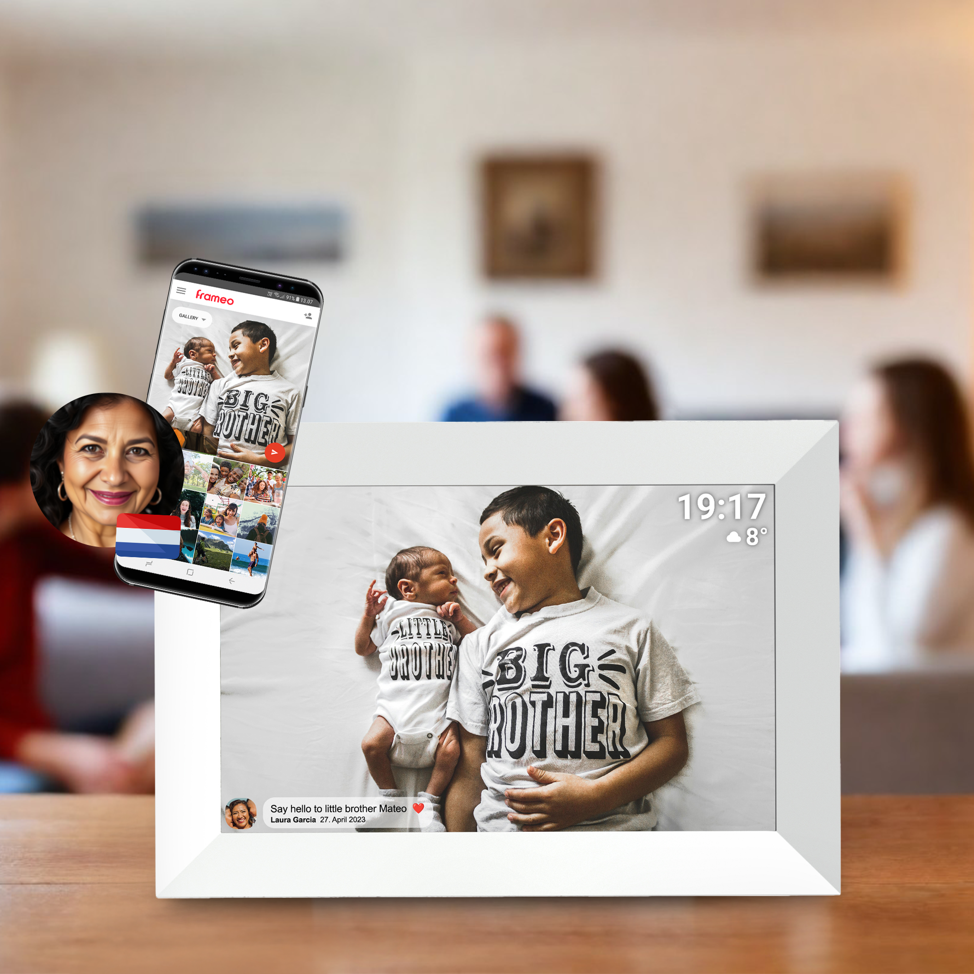 Digital photo frame displaying two babies in a bed. A phone shows the same image.