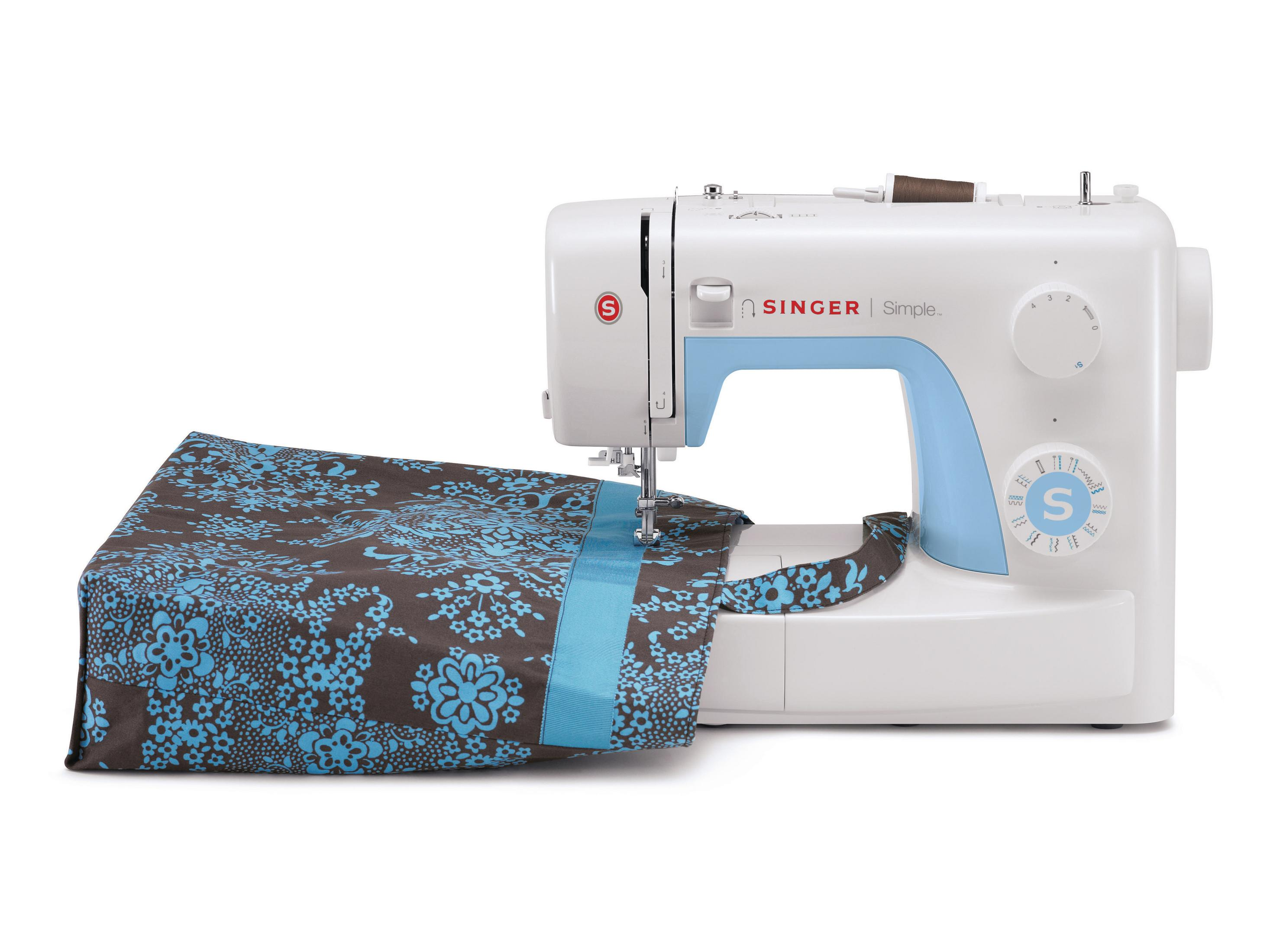 Biała maszyna do szycia Singer szyjąca torbę z niebiesko-brązowym wzorem kwiatowym.