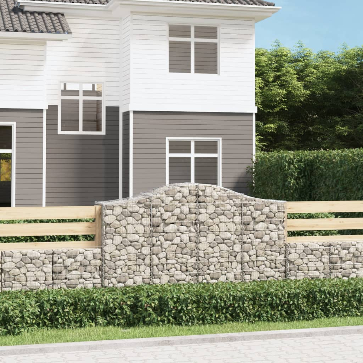 Ein Haus mit einem Stein- und Drahtzaun, mit grünem Gestrüpp und Gras davor.