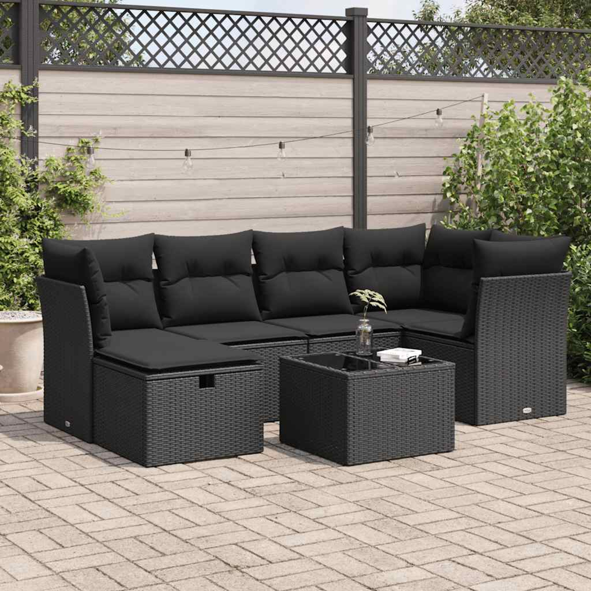 Schwarzes Rattan-Gartenmöbel-Set, einschließlich Sofa, Tisch und Ottoman, auf einer Terrasse.