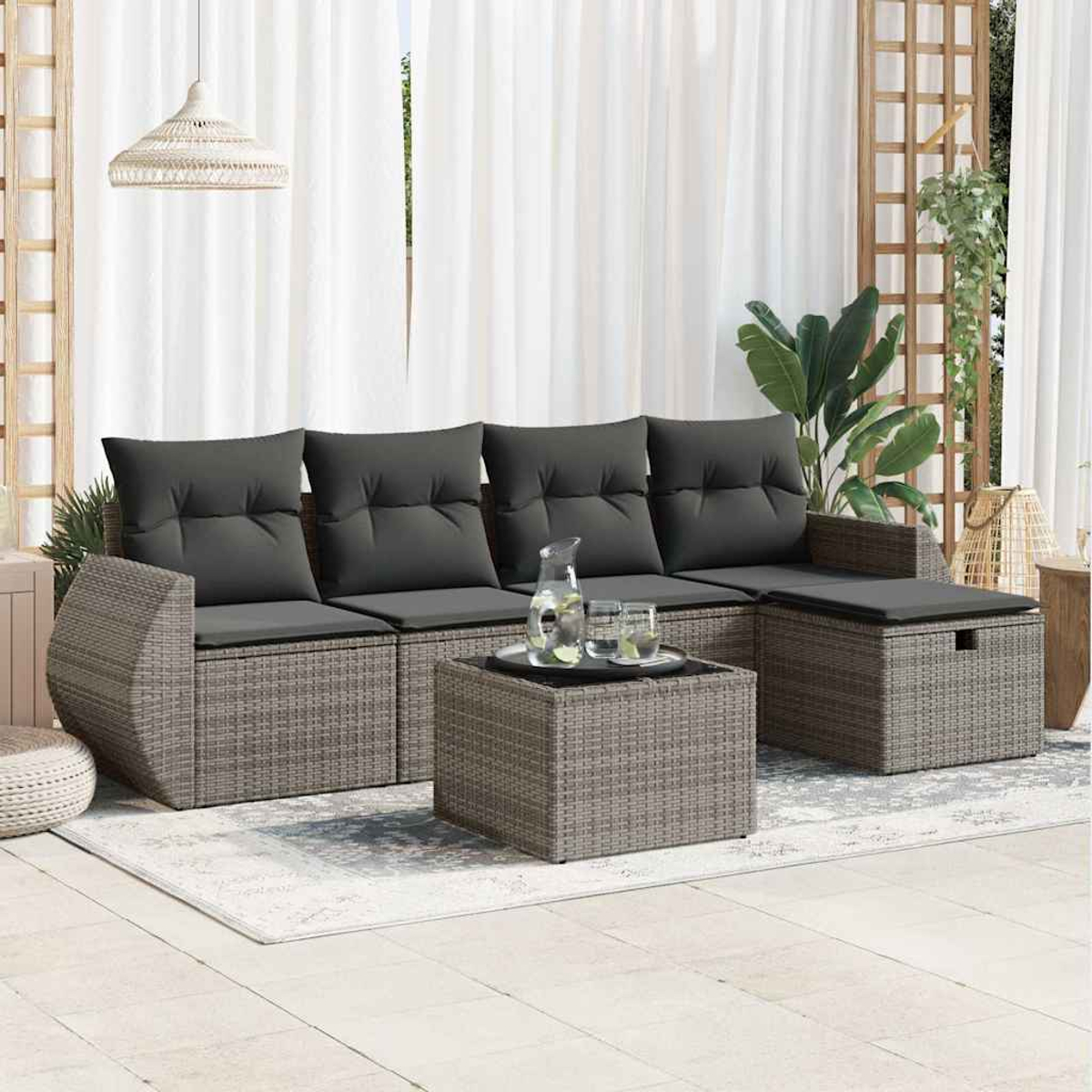 Ein Rattan-Outdoor-Ecksofa-Set mit grauen Kissen und einem Couchtisch.