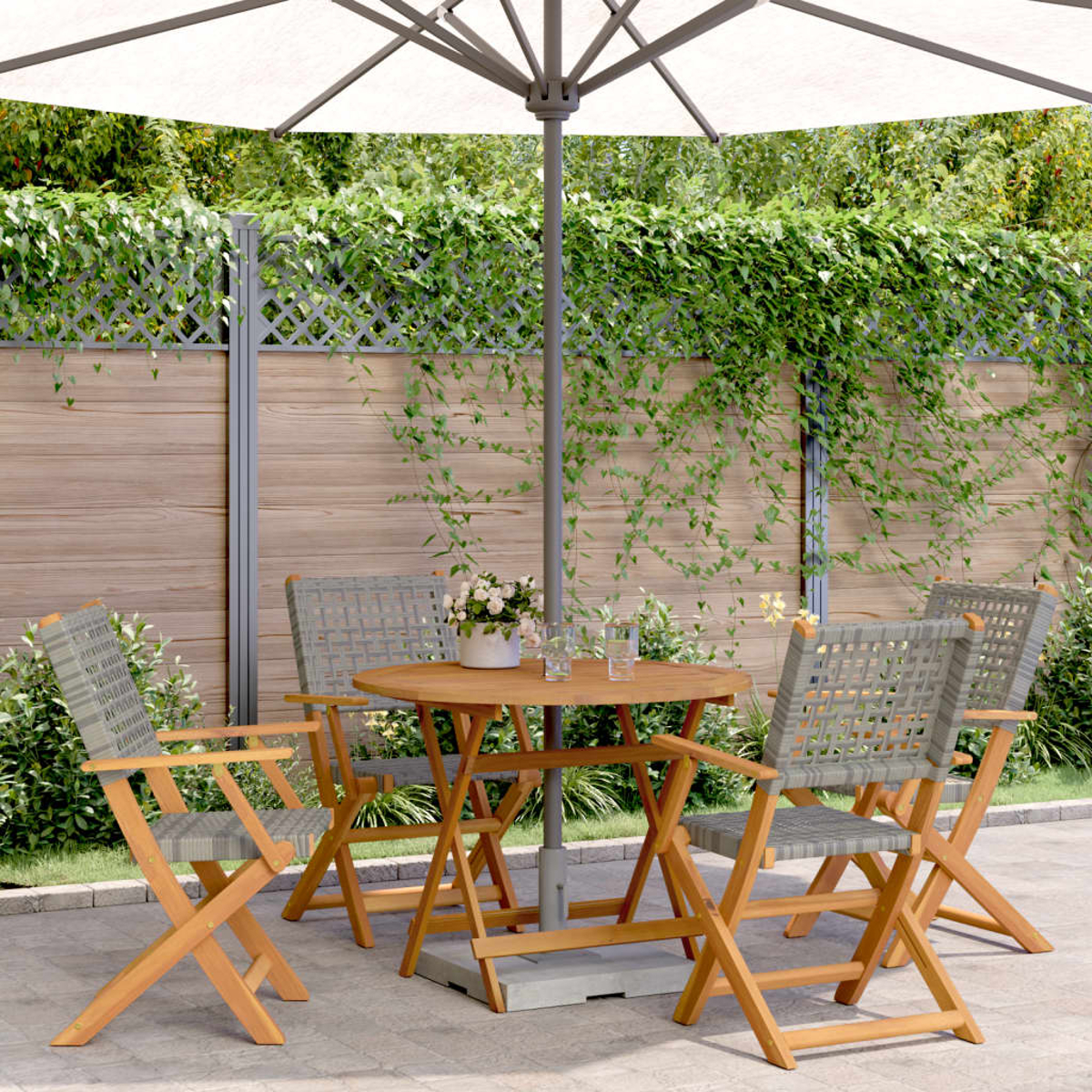 Terrassenset: runder Tisch, Stühle und Sonnenschirm. Der Hintergrund ist ein Holzzaun.