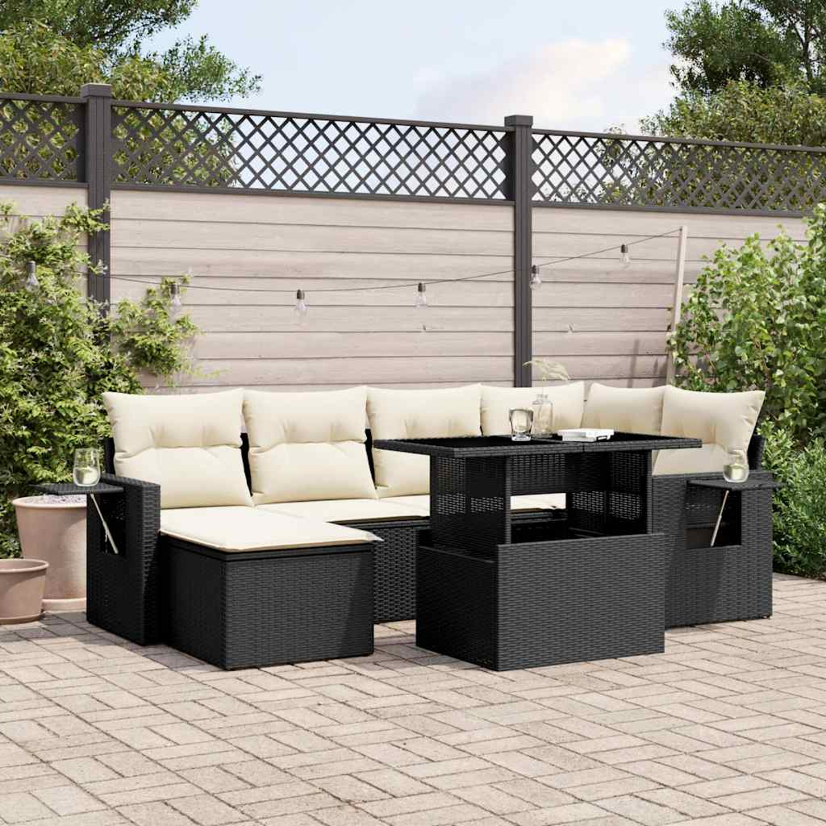 Schwarzes Rattan-Ecksofa im Freien mit Tisch. Ziegelterrasse, Gras und Zaun im Hintergrund.