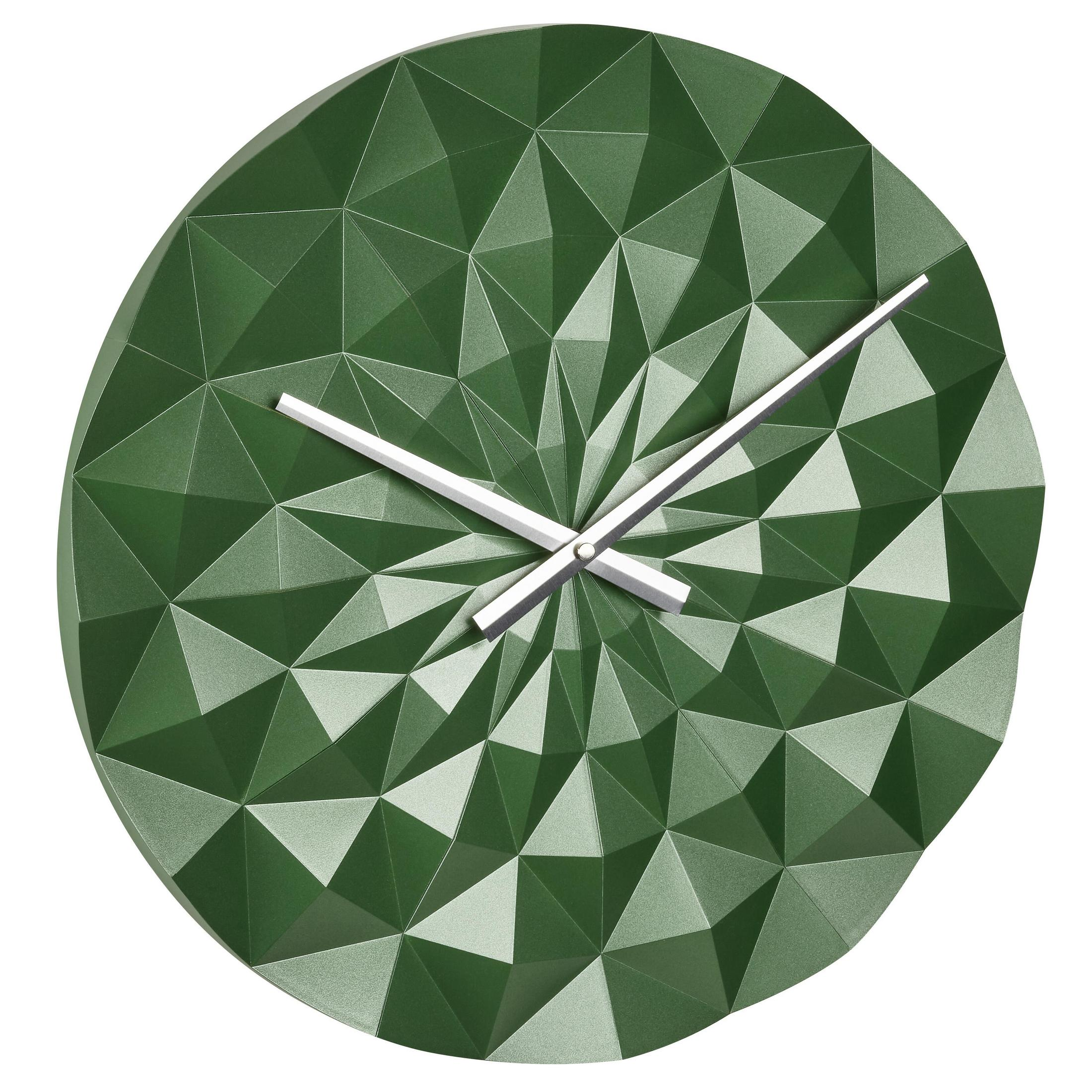 Eine grüne Wanduhr mit geometrischem Muster. Die Zeiger stehen auf zehn nach zehn.