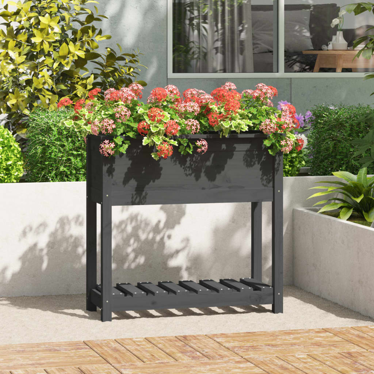 Schwarzer Holzpflanzer mit roten Blumen auf einer Terrasse. Hintergrund zeigt Gebäude und Grün.
