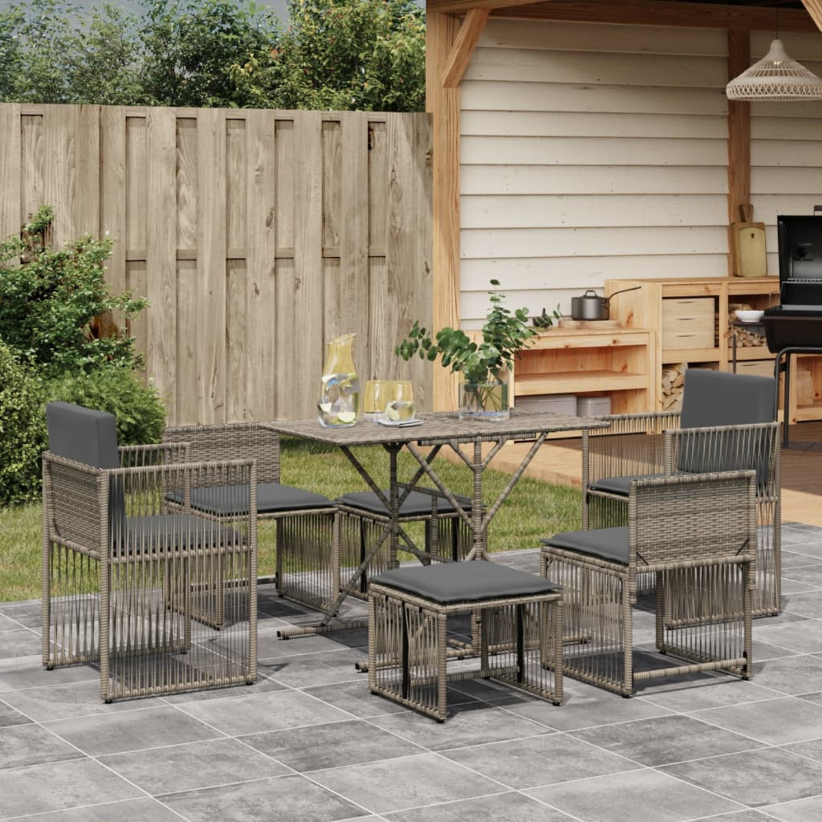Set da patio per esterni. Mobili in stile rattan con cuscini grigi. Include tavolo, sedie e pouf.