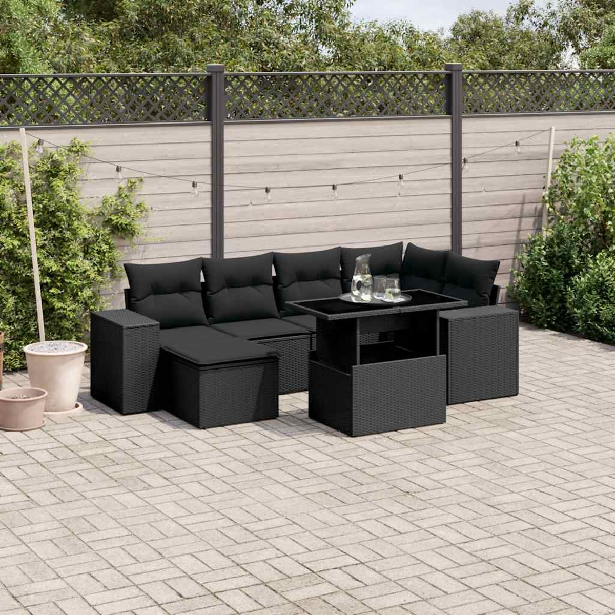 Schwarzes Outdoor-Sofaset mit Couchtisch. Schwarze Kissen, Terrasseneinstellung.