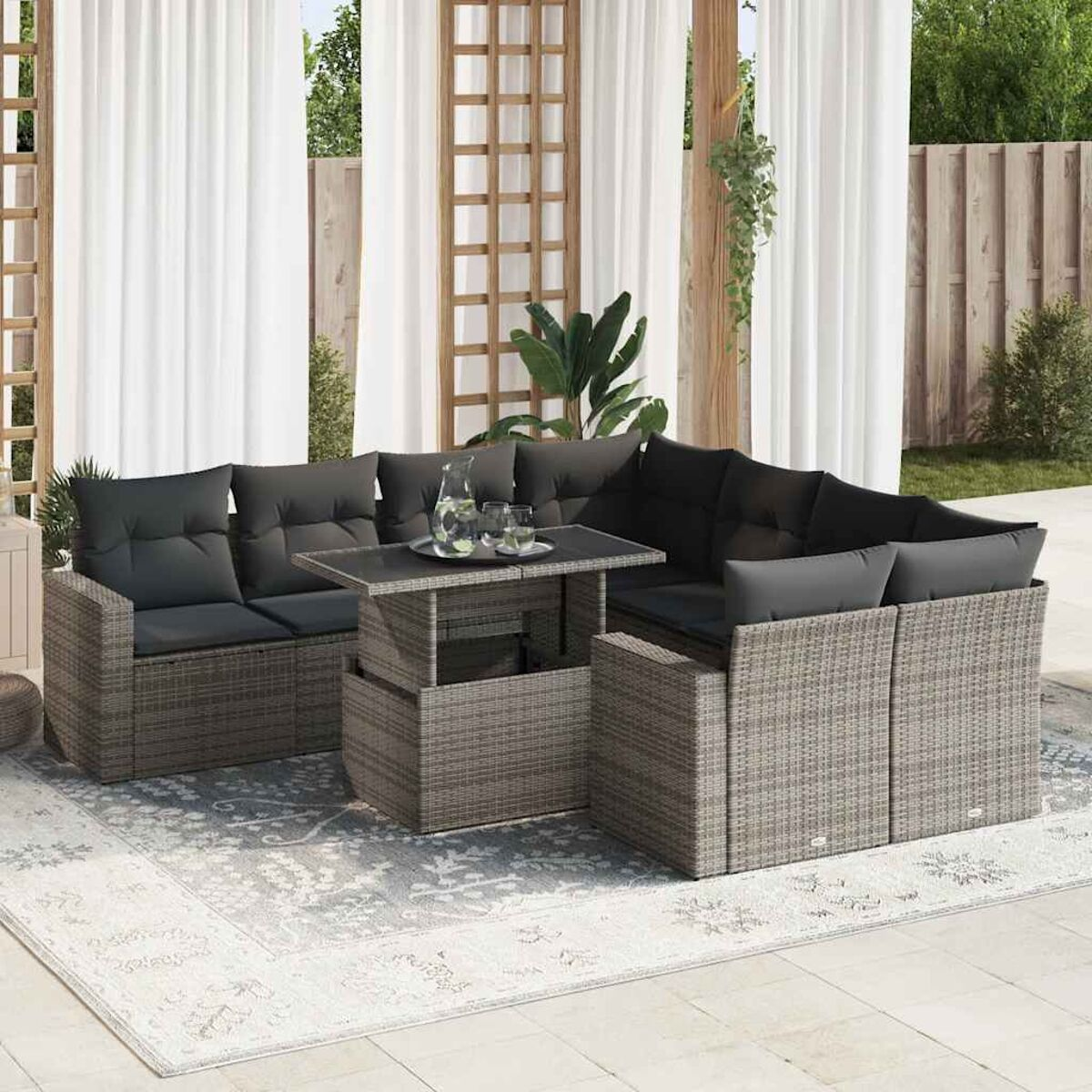 Ein graues Ecksofa im Freien mit einem Tisch mit aufklappbarer Platte auf einem gemusterten Teppich.