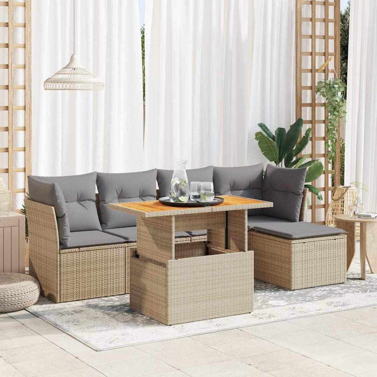 Scena del patio con divano componibile in rattan, tavolo e cuscini grigi.
