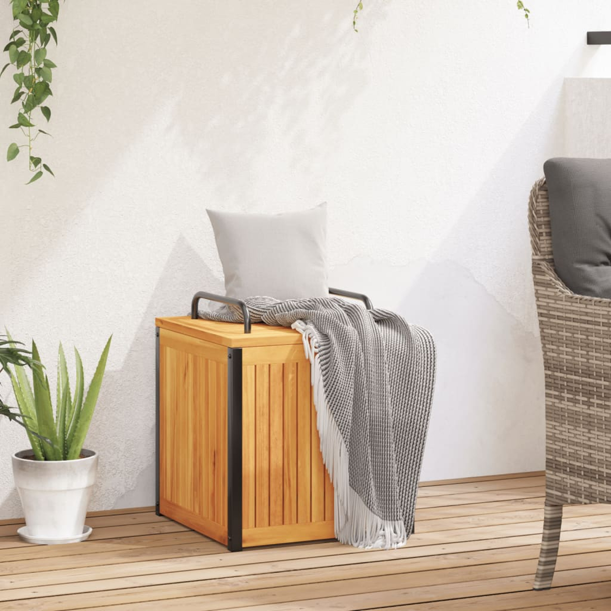 Holzaufbewahrungsbox mit Kissen und Decke. Pflanzen im Hintergrund.