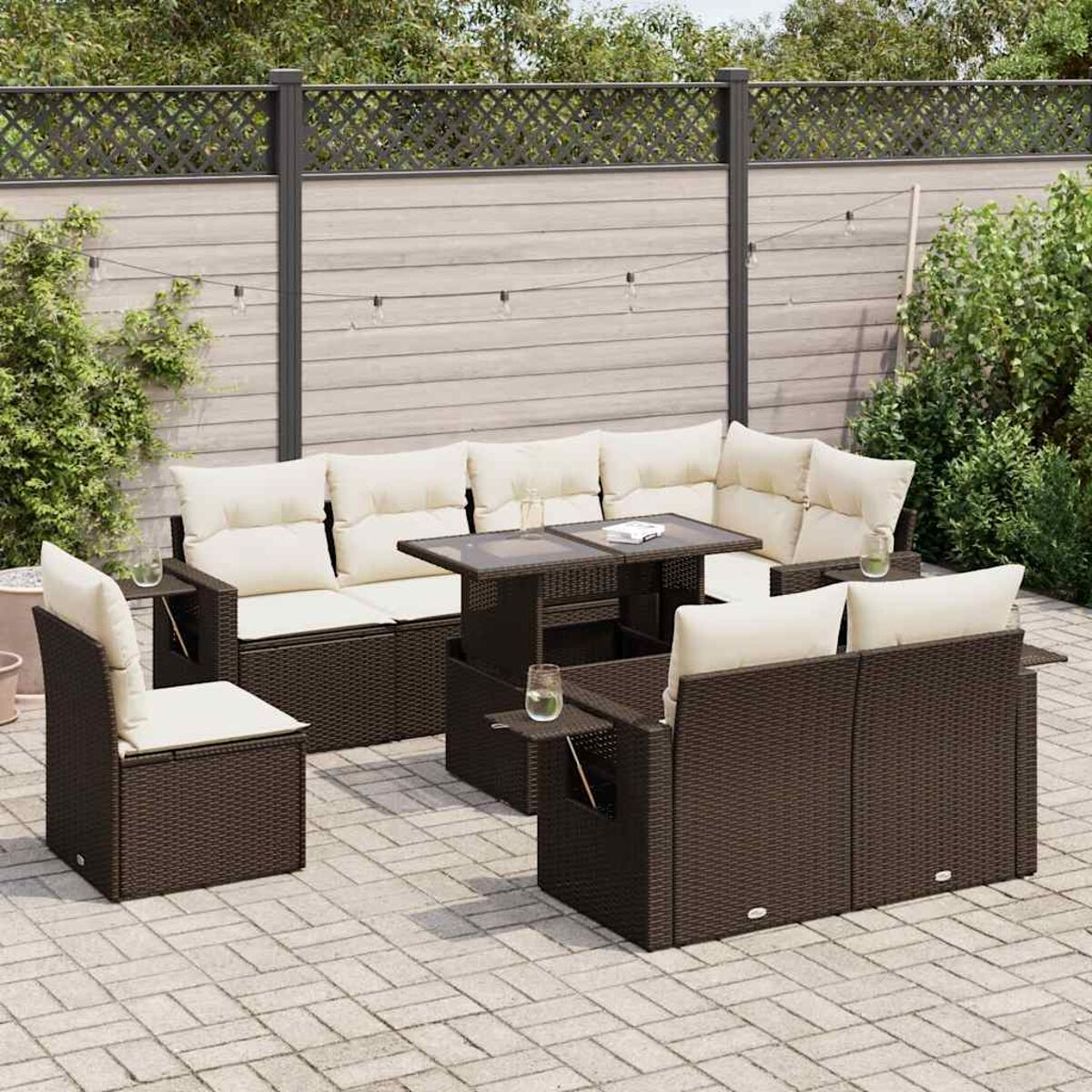 Set da patio in rattan marrone con cuscini beige, tavolo e sedie, su un patio.