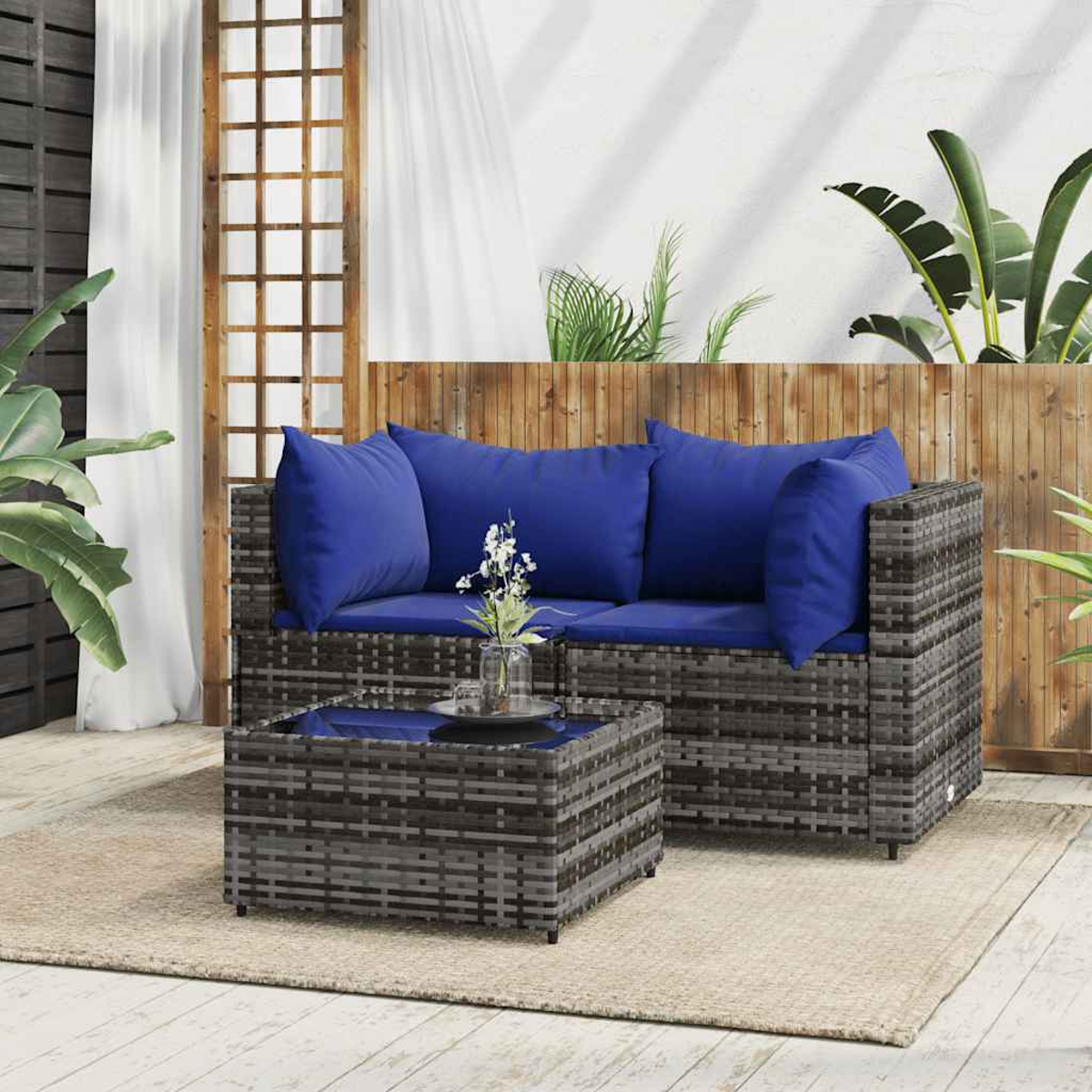 Outdoor-Korbsessel-Set mit blauen Kissen und einem kleinen Tisch.