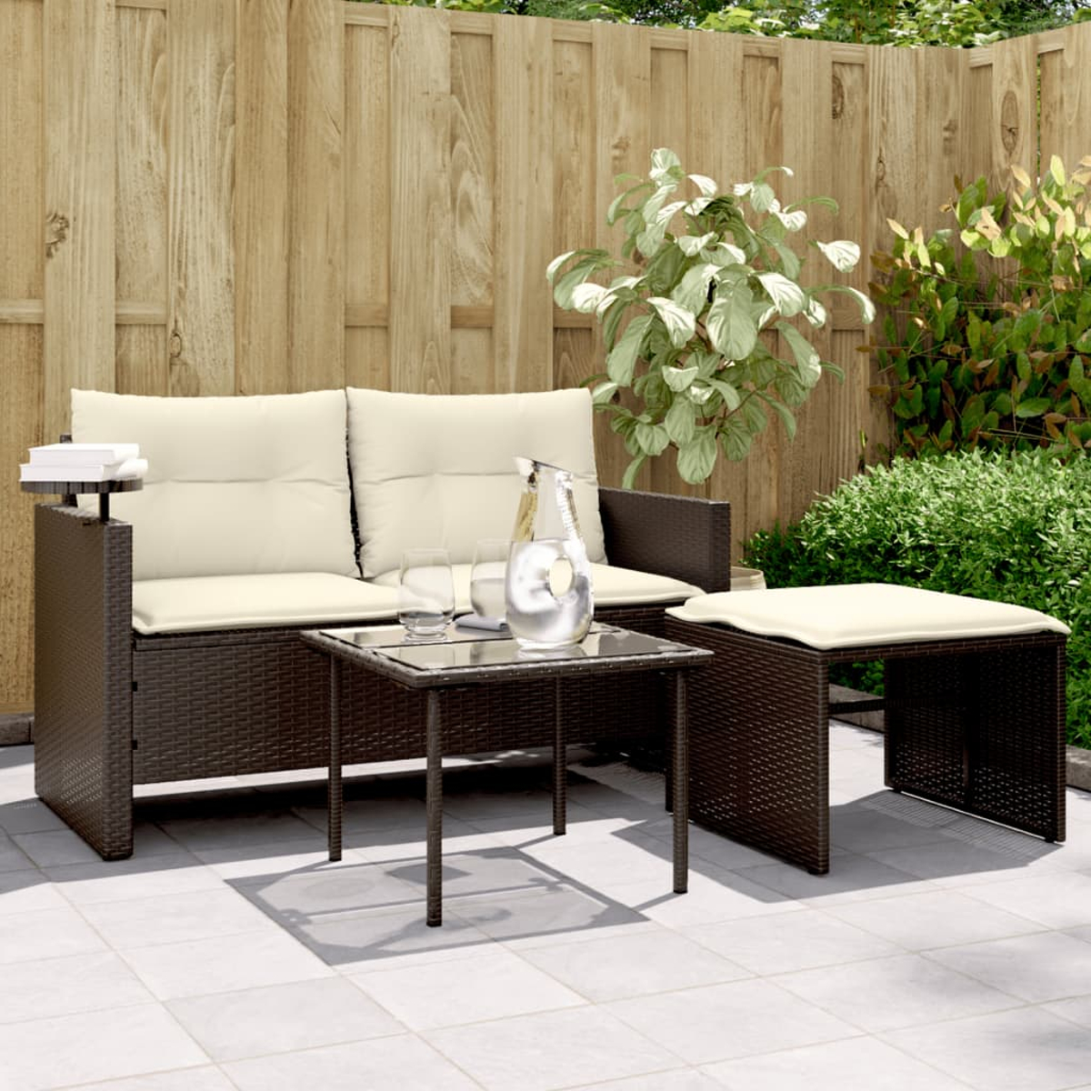 Geflochtene Sofagarnitur mit Couchtisch, Wasserkrug und Gläsern auf einer Terrasse.