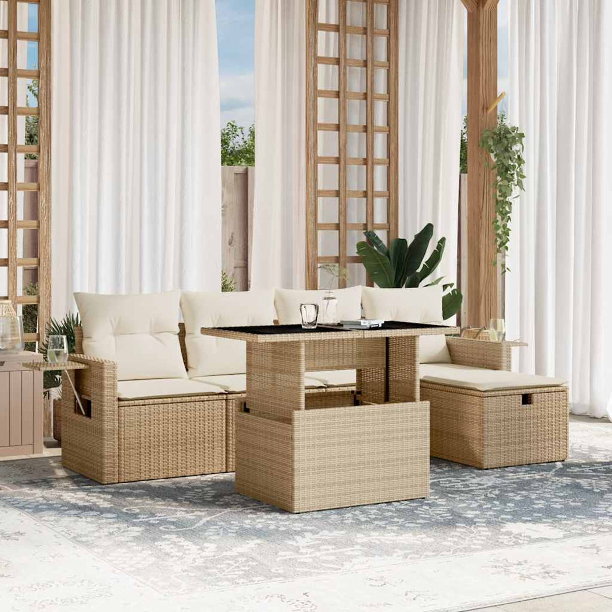 Divano in rattan beige con tavolo sollevabile. Tende bianche sullo sfondo.