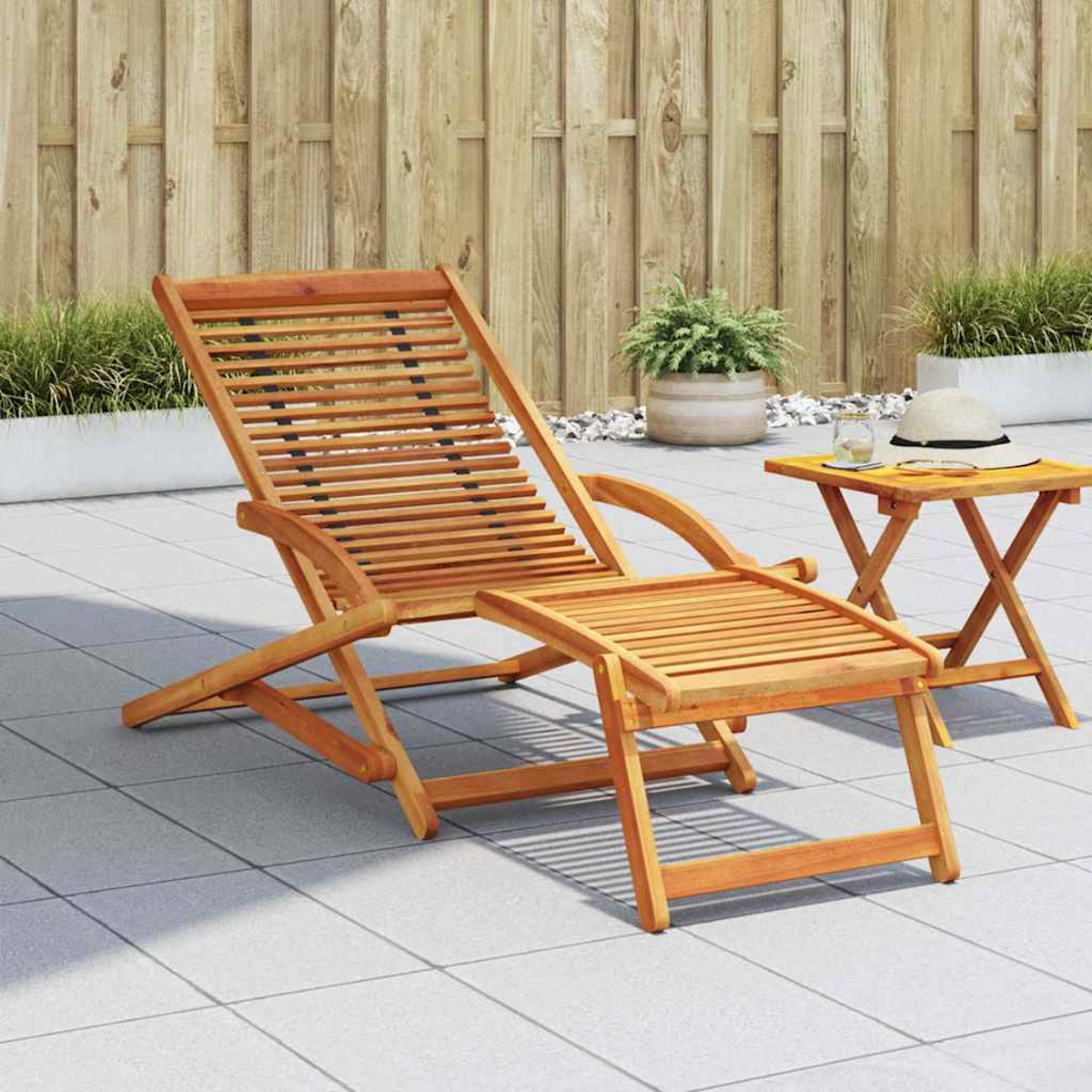 Holzliegestuhl mit Fußstütze und kleinem Beistelltisch, Außenbereich.