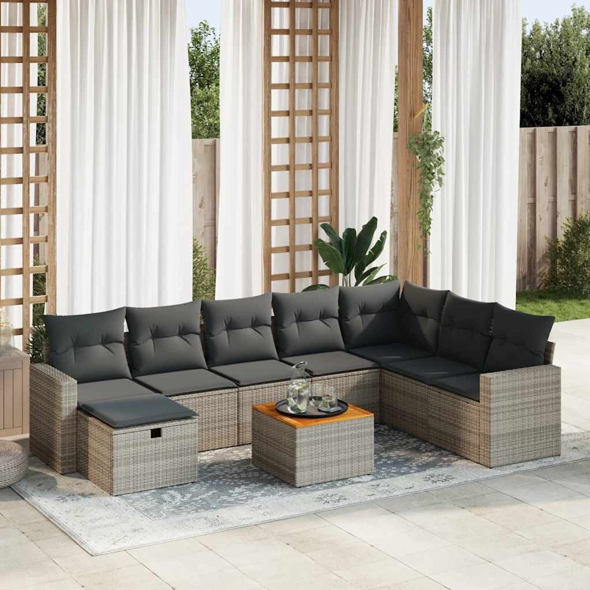 Ein Outdoor-Sofaset mit einem Couchtisch. Es befindet sich auf einer Terrasse, mit Vorhängen im Hintergrund.