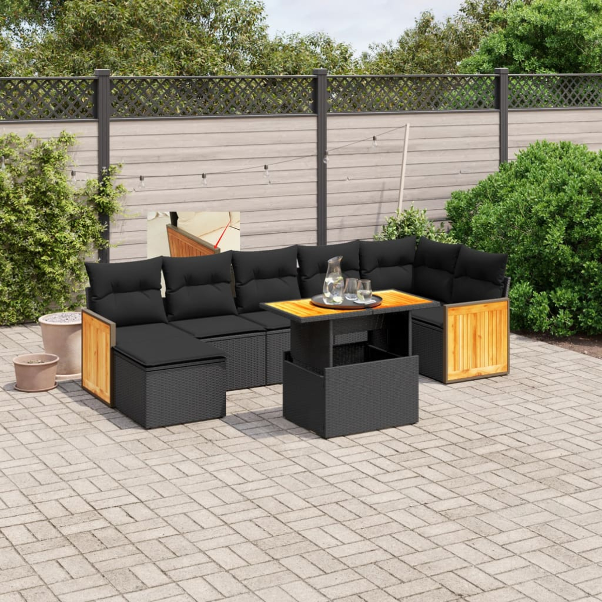 Garten-Terrassenset mit schwarzen Korbmöbeln. Enthält ein Sofa, einen Tisch und zwei Beistelltische. Schwarze Kissen vorhanden.