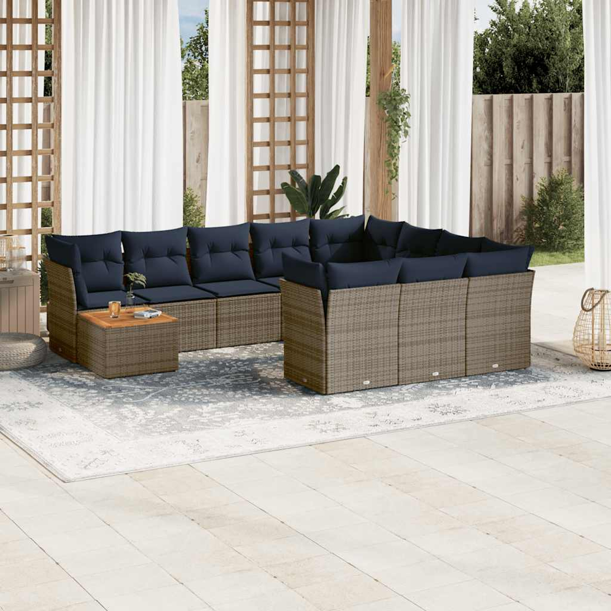Divano componibile in rattan per esterni con cuscini blu, un tavolo in legno e un tappeto.