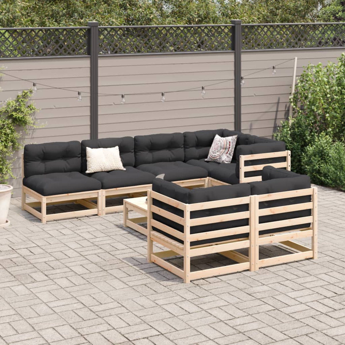 Terrasse mit schwarzen Sitzmöbeln und einem weißen Tisch.