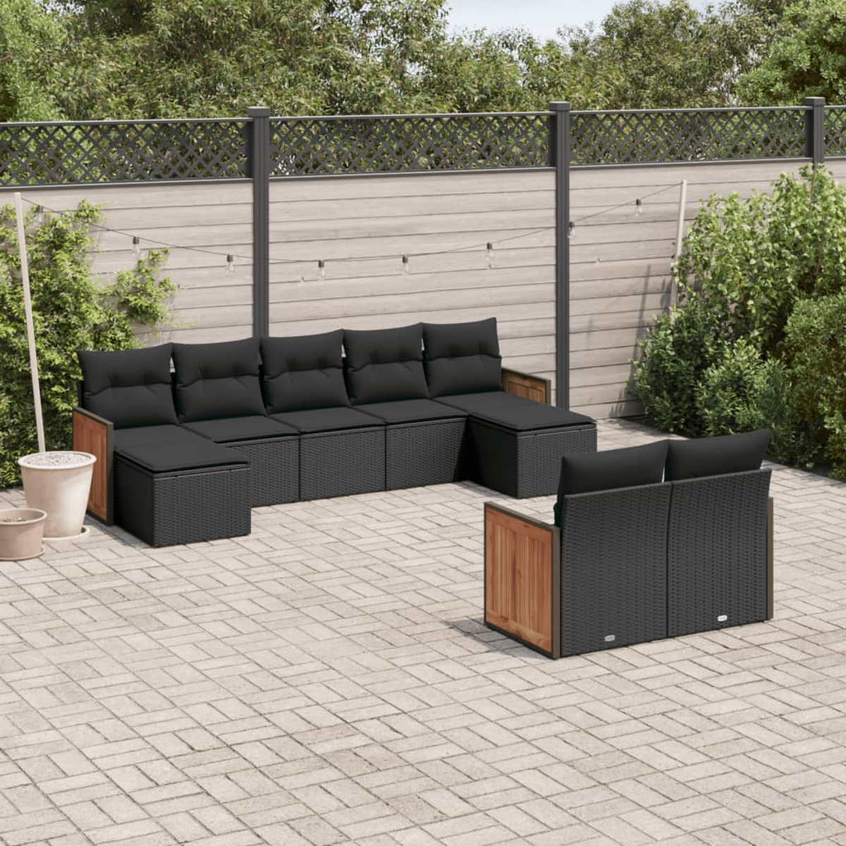 Schwarzes Outdoor-Ecksofa aus Korbgeflecht mit Holzakzenten und schwarzen Kissen.