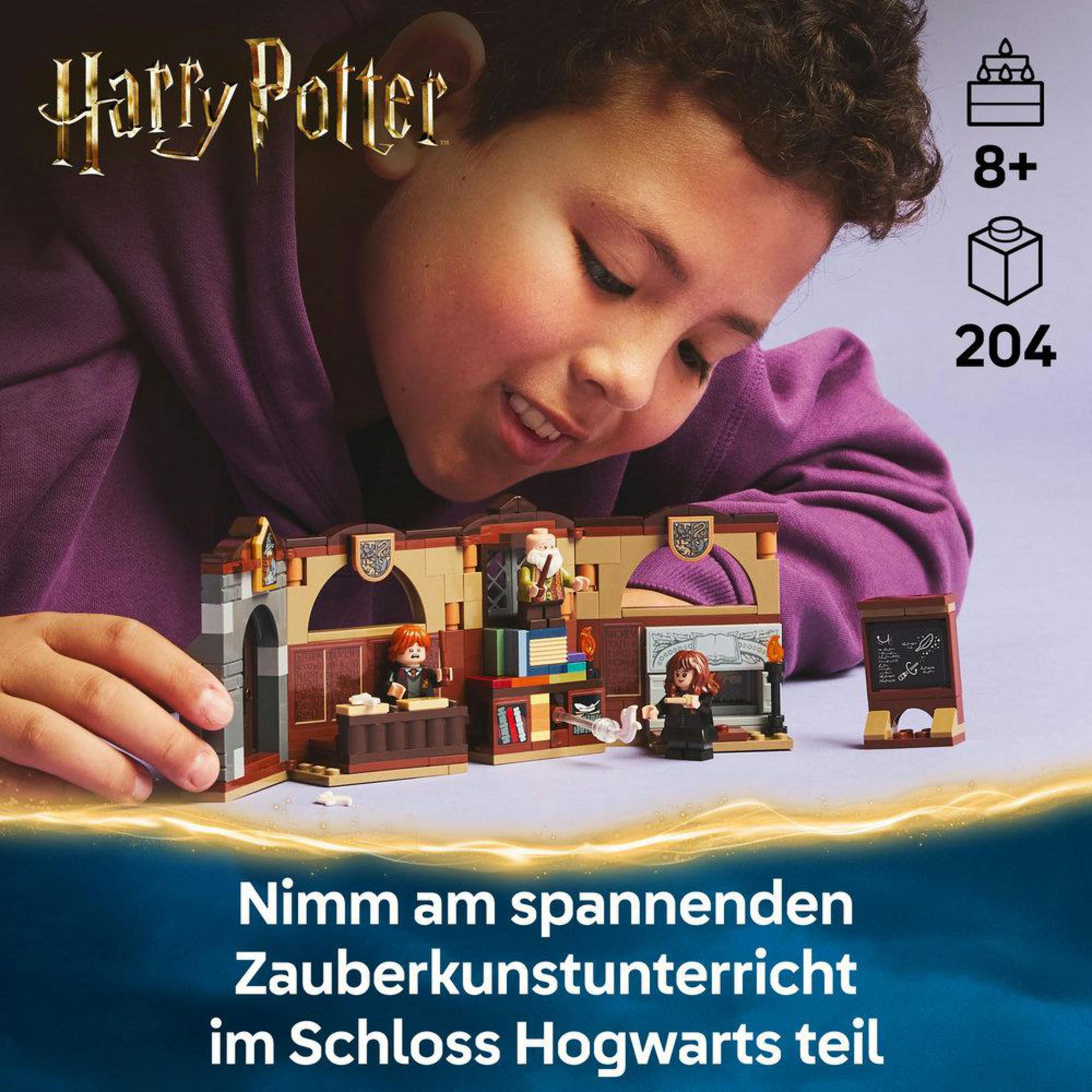 Chłopiec uśmiecha się, budując scenę w klasie Lego Harry Potter. Pudełko zestawu jest w tle.