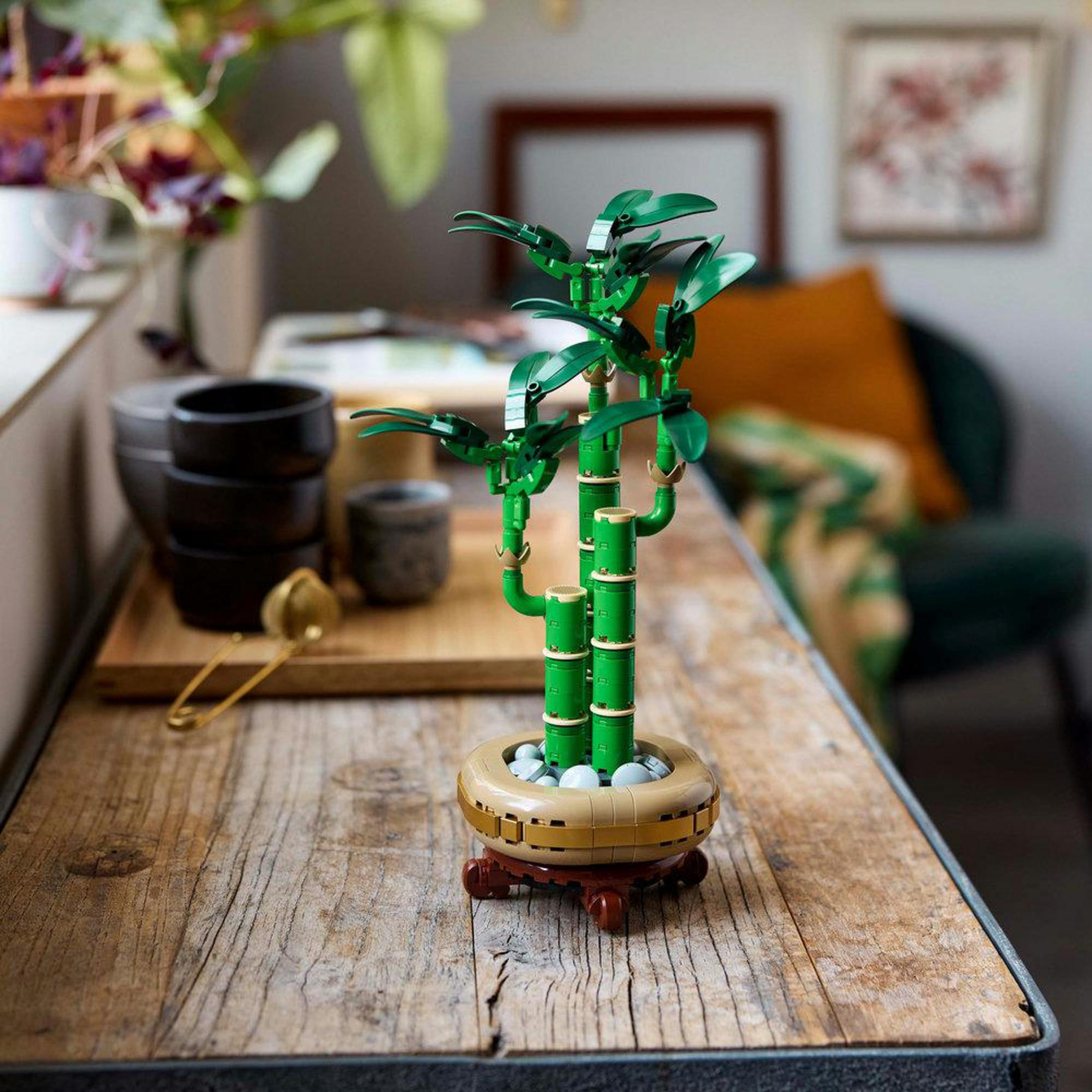 LEGO Botanicals Lucky Bamboo plant op een houten oppervlak. Groene bamboestengels in een bruine pot.