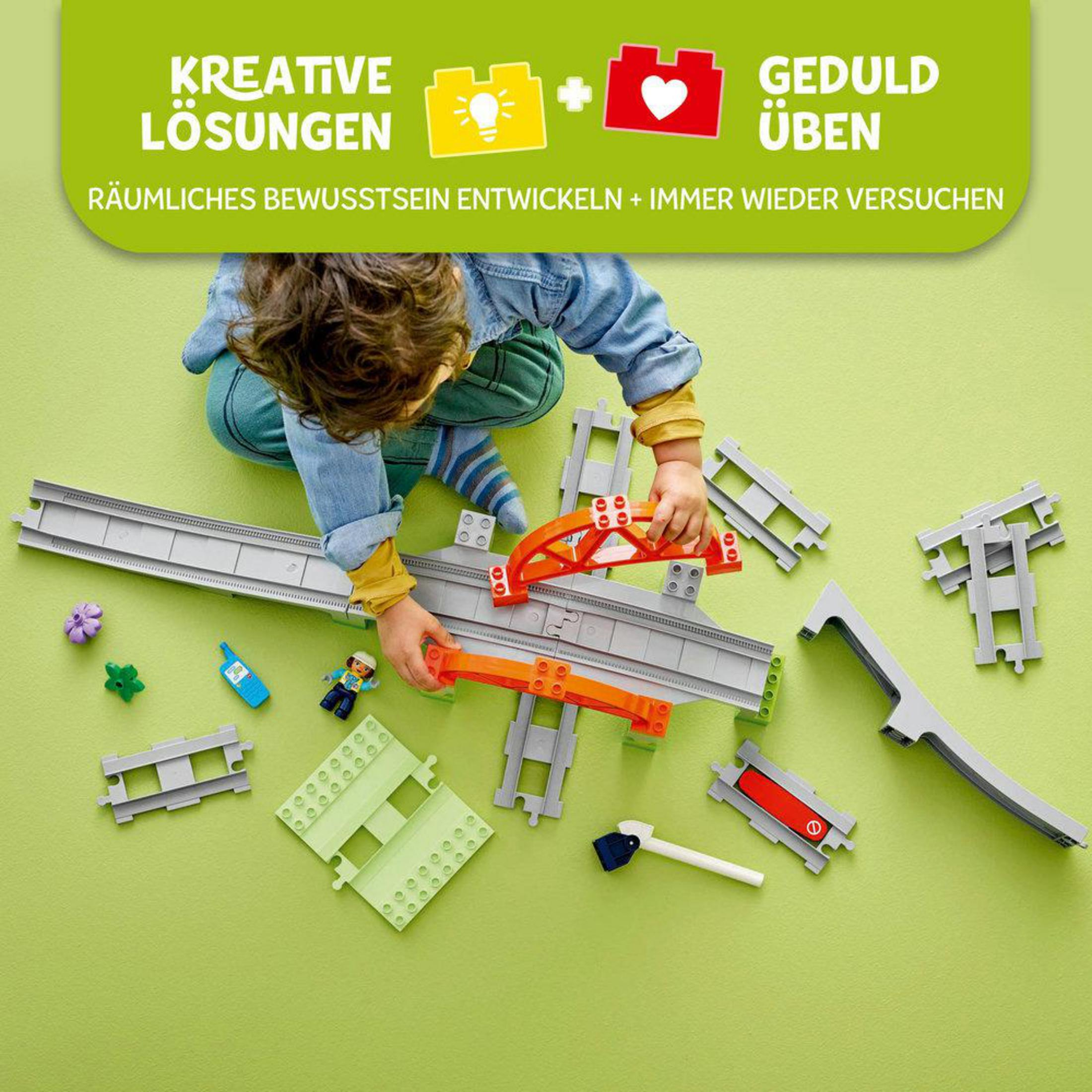 Dziecko bawi się zestawem Lego Duplo, w tym mostem i torami.