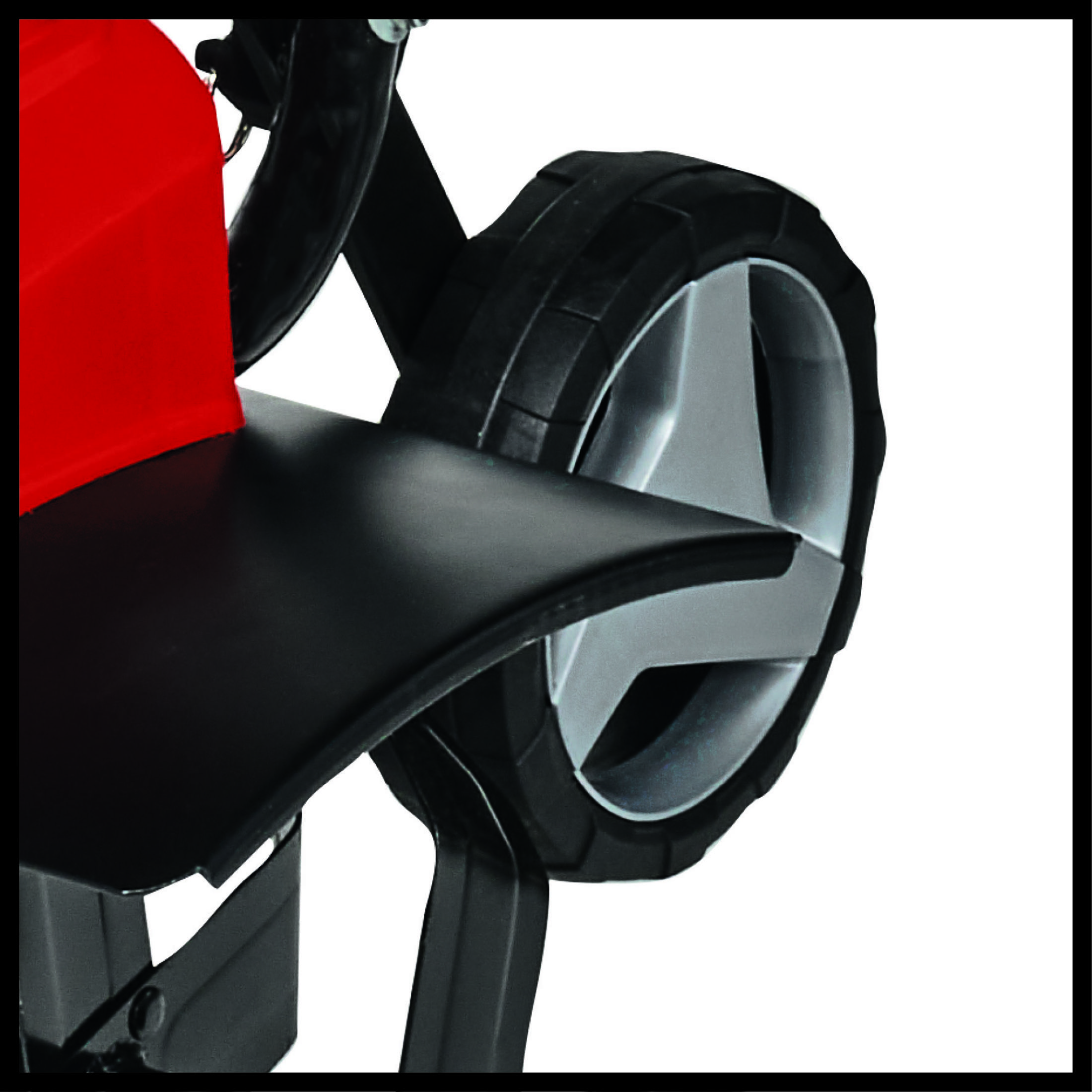 Zbliżenie czarnego koła ze srebrnym środkiem. Koło jest na czerwonej maszynie.