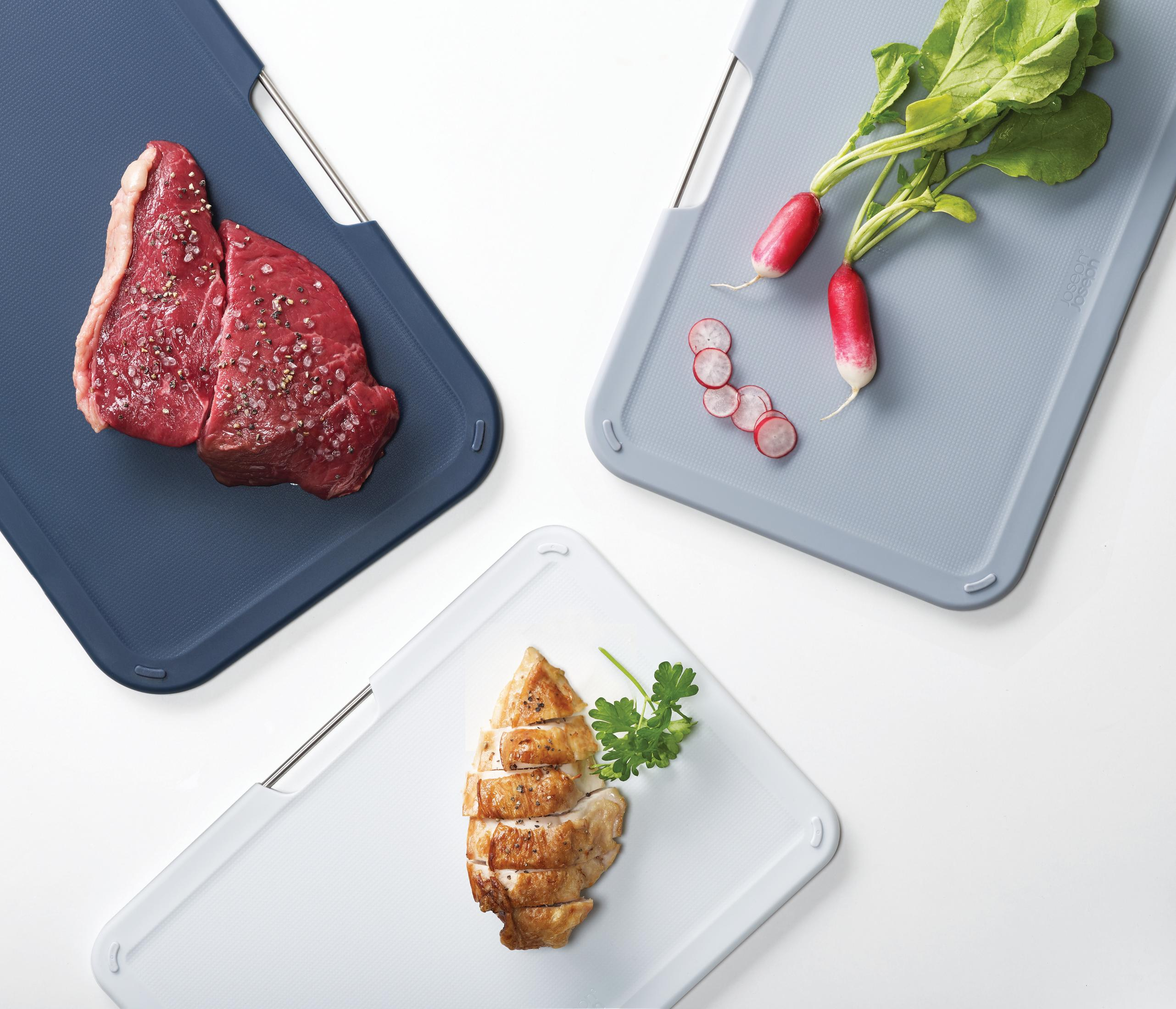 Schneidebretter mit Steak, Radieschen und geschnittenem Hühnchen.
