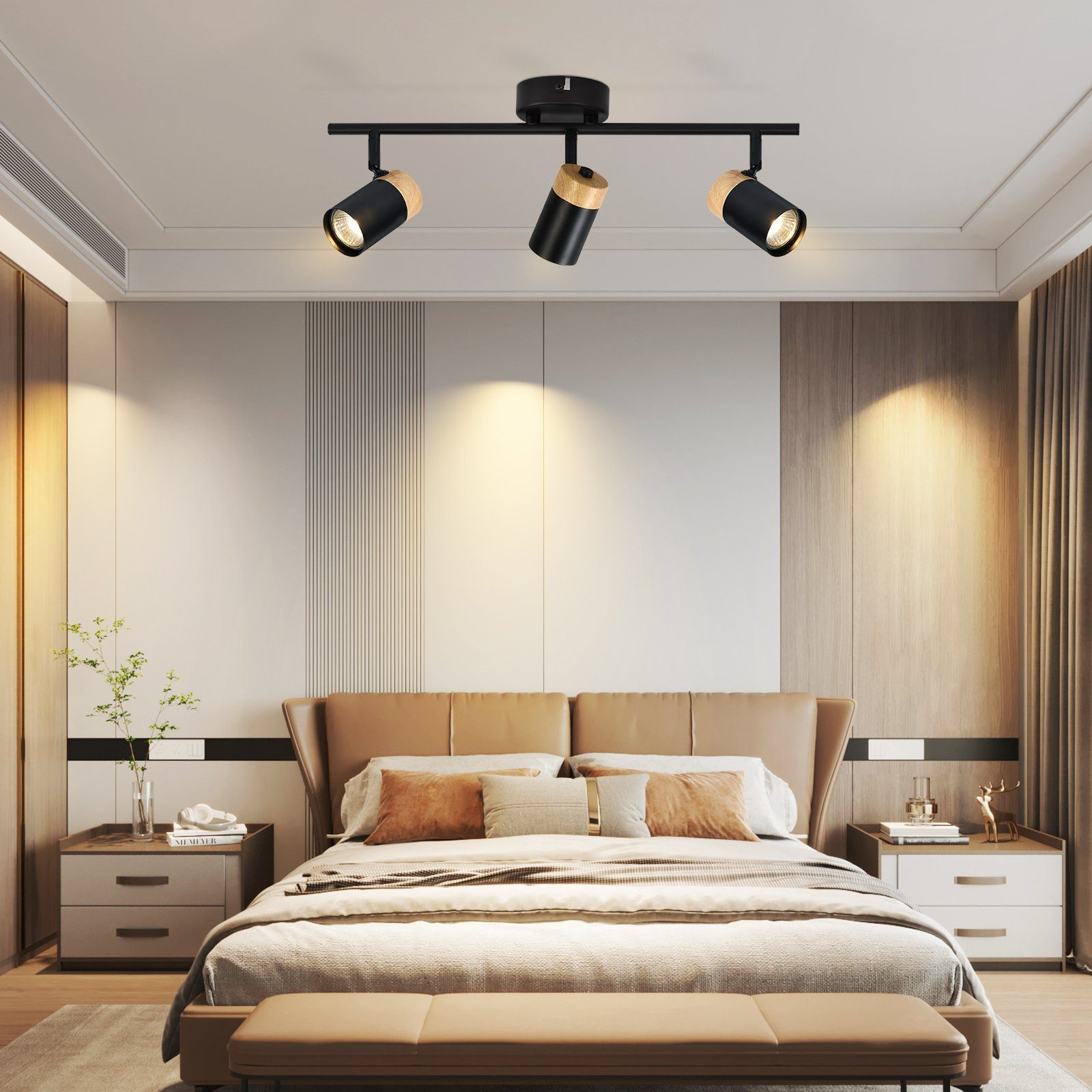 Camera da letto illuminata da lampade a soffitto nere con dettagli in legno. Letto con testiera marrone.