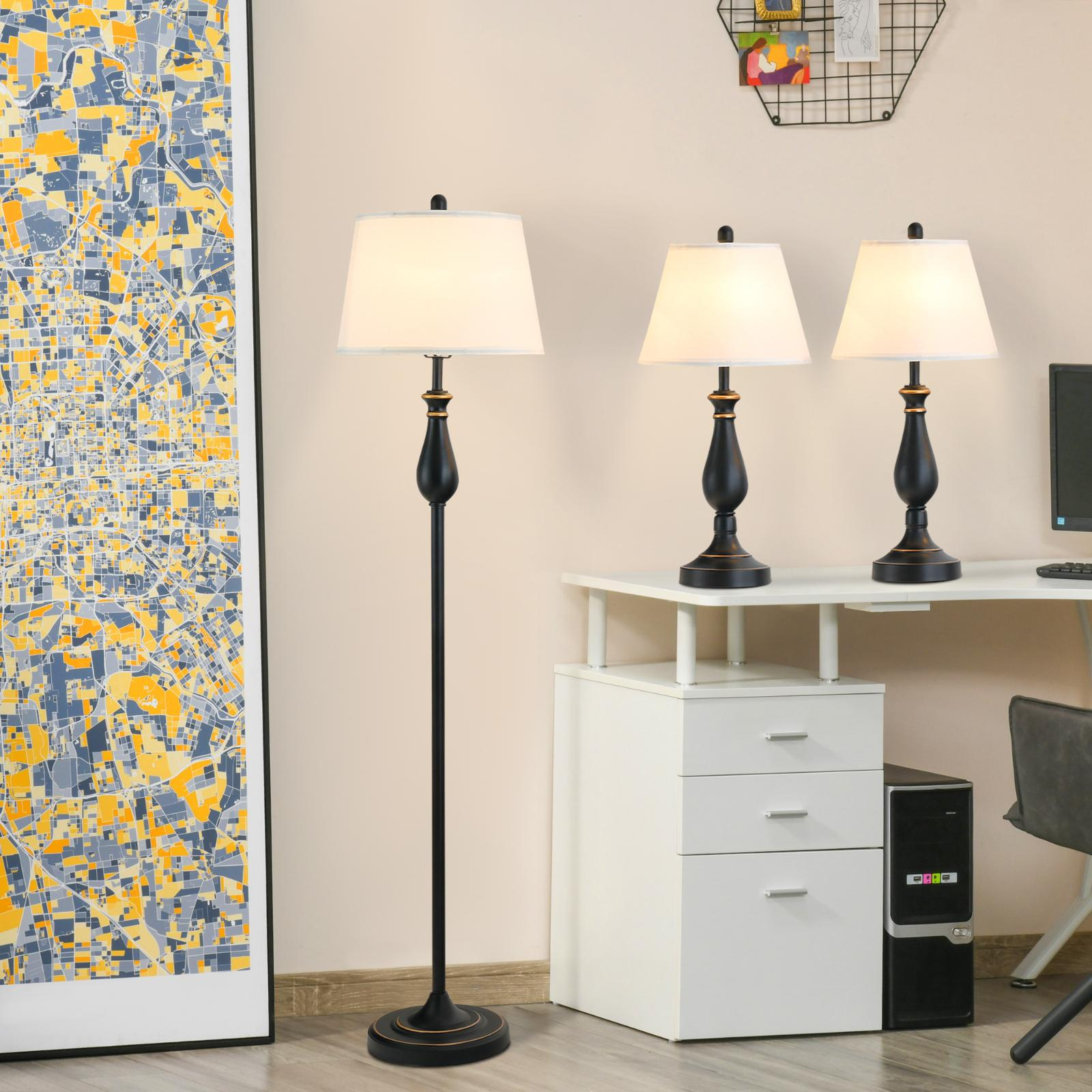 Eine Stehlampe und zwei Tischlampen auf einem Schreibtisch. Ein Gemälde und ein Computer sind sichtbar.
