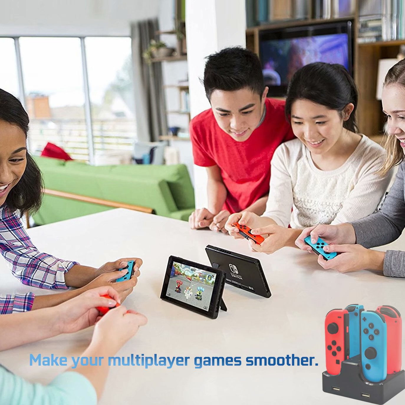 Vier Personen spielen Switch. Zwei Switch-Konsolen auf einem Tisch mit Joy-Con-Controllern und Ladestation.