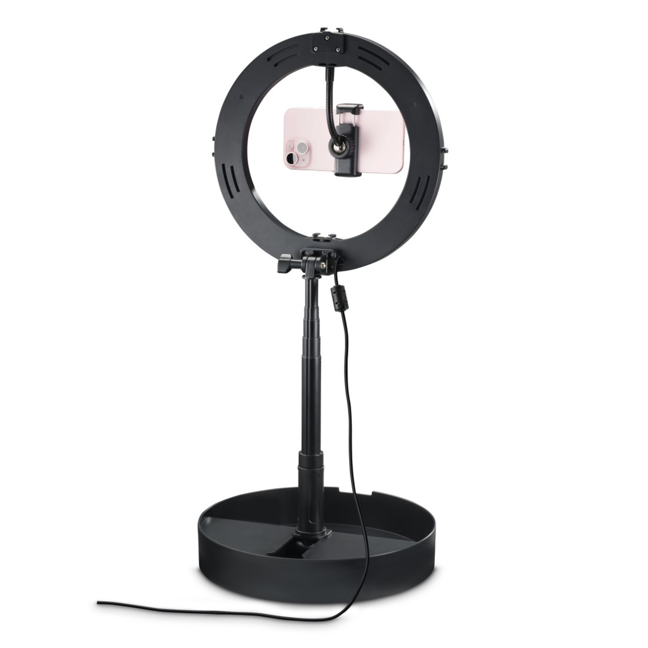 Czarne światło pierścieniowe z telefonem pośrodku i statywem, na białym tle.