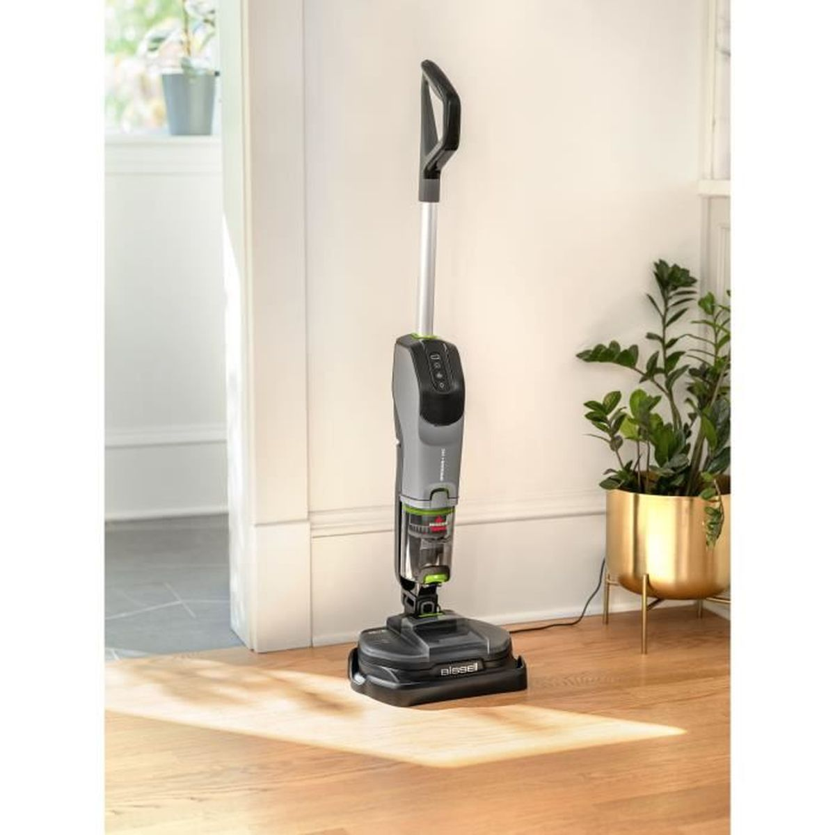 Ein kabelloser Staubsauger steht auf einem Hartholzboden neben einer Pflanze und zeigt sein Design und seine Funktionen.