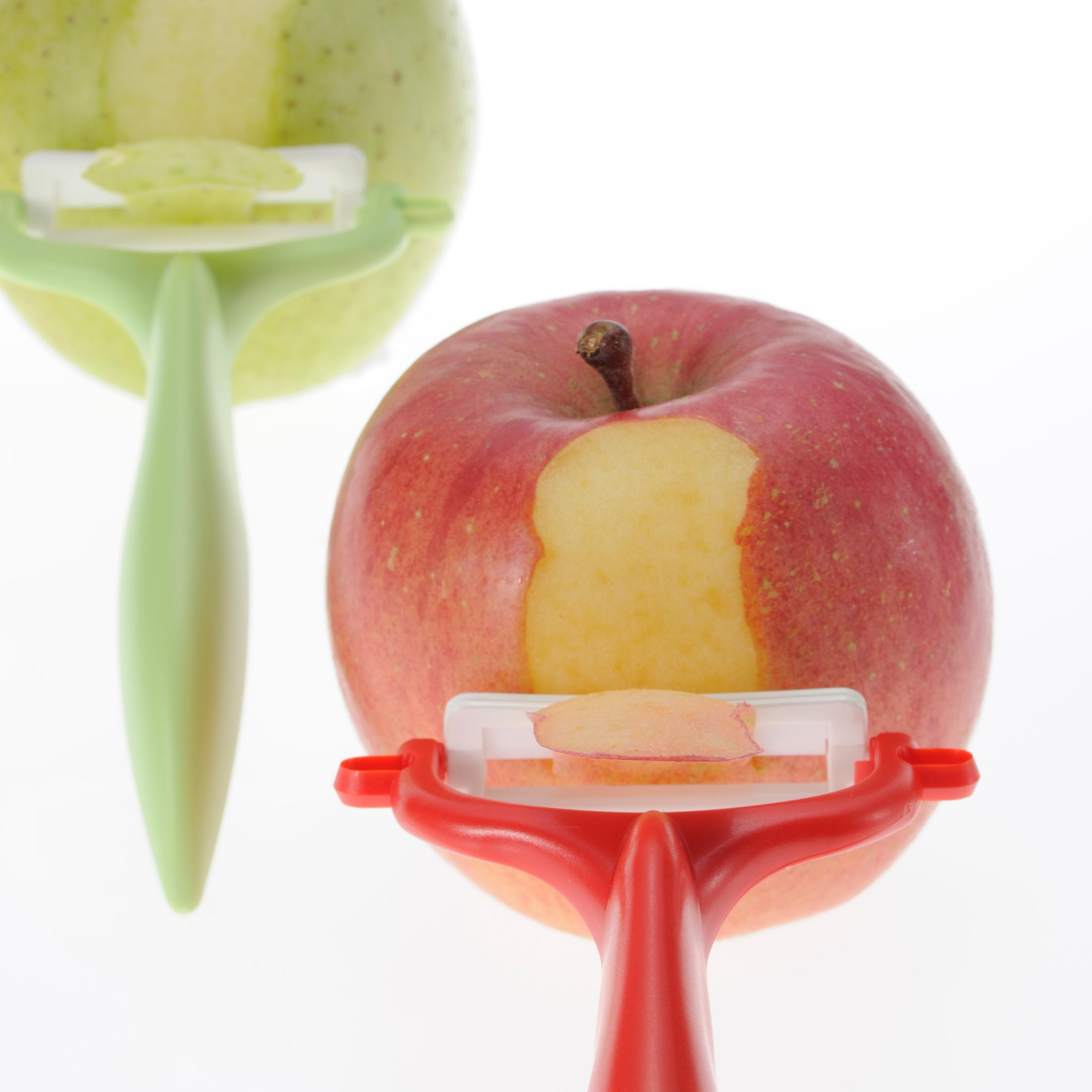 Zwei Äpfel mit Schäler. Ein Apfel wird geschält, der andere ist geschält.