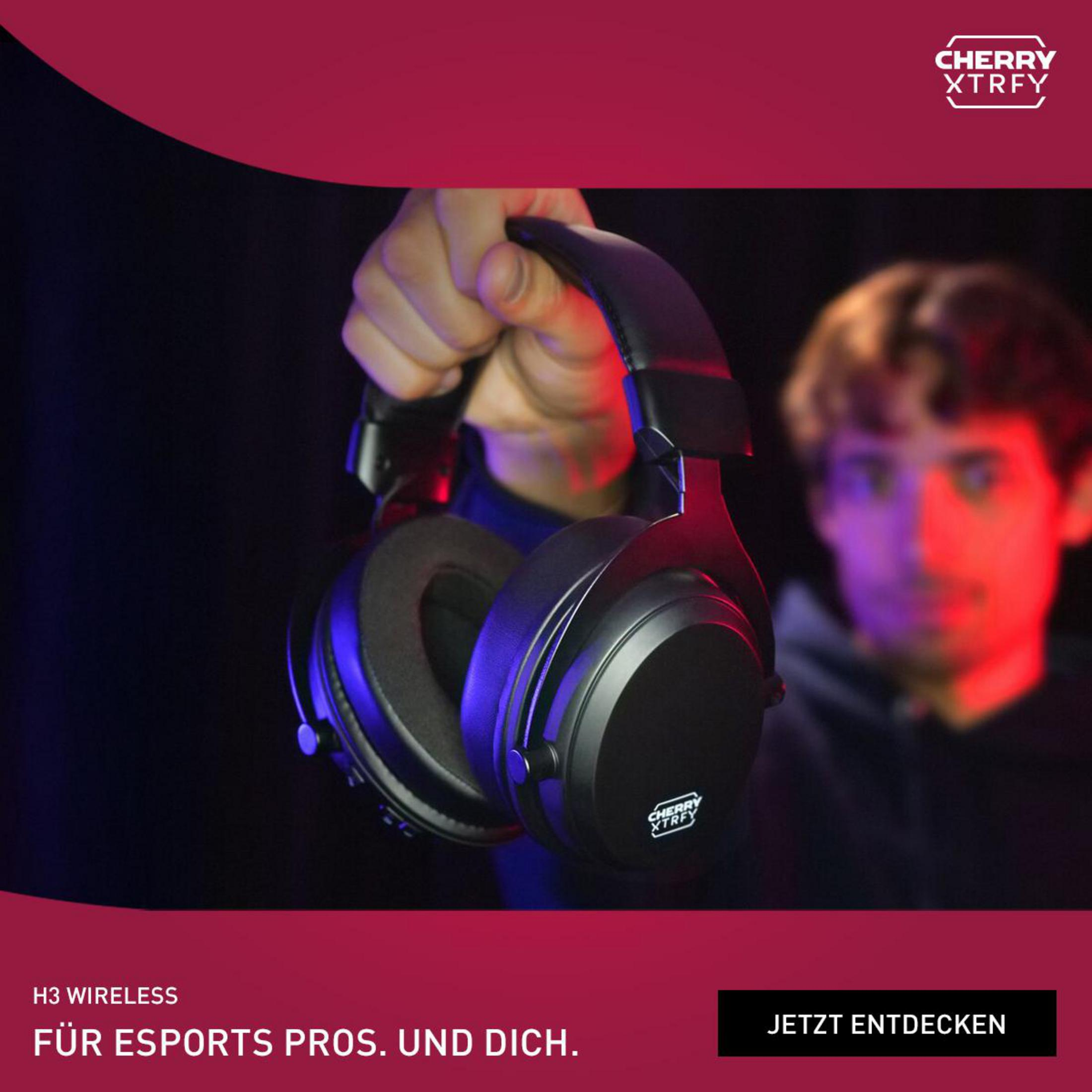 Une personne tenant un casque noir. Le casque porte la marque CHERRY XTRFY.