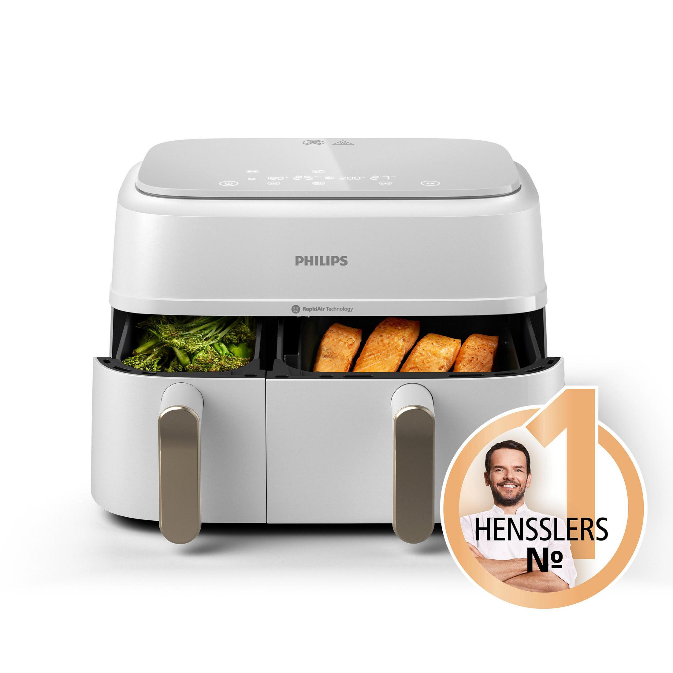 Biała i szara frytkownica powietrzna z jedzeniem w tackach. Mężczyzna jest w rogu.