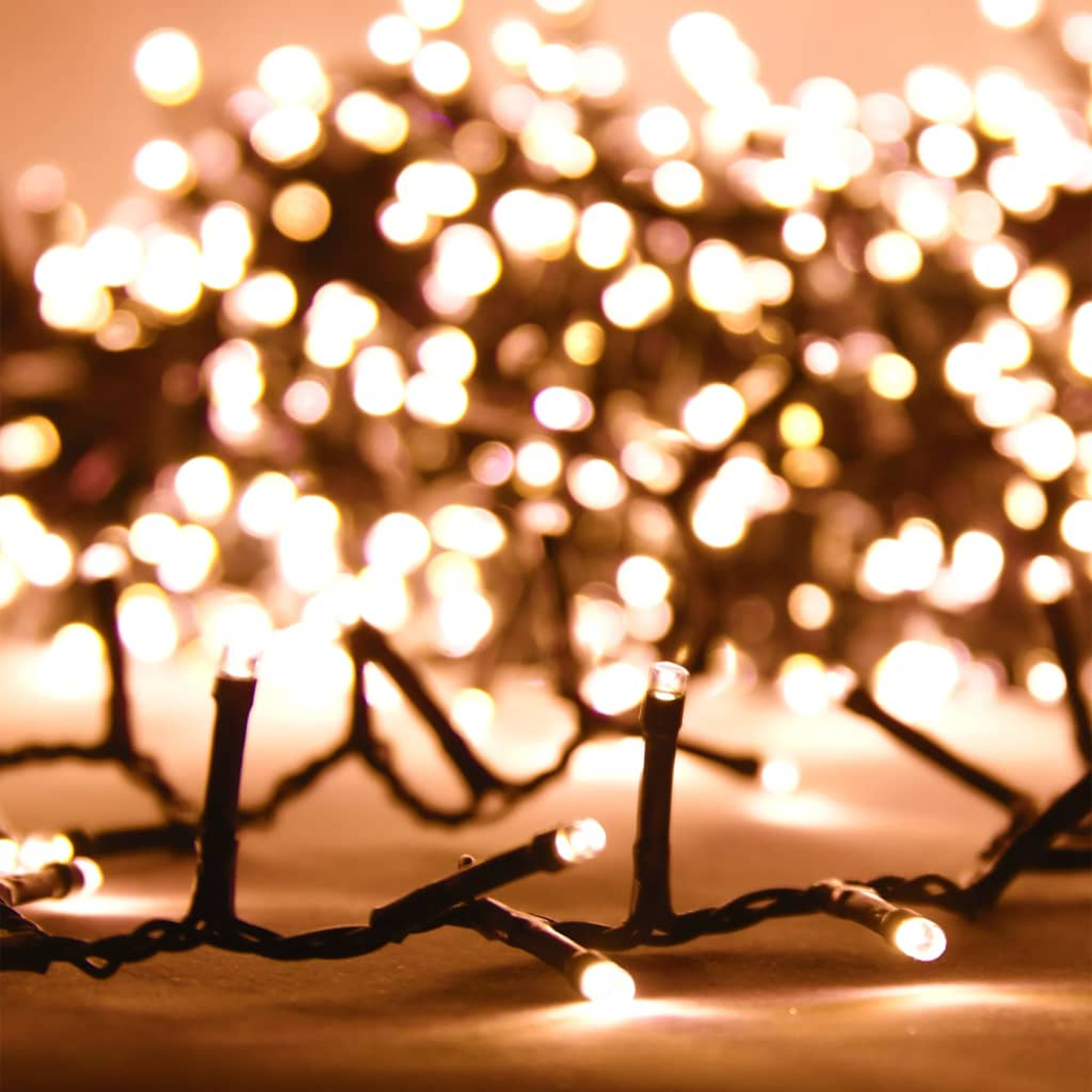 Lichterketten mit kleinen, warmweißen LEDs. Die Lichter sind auf einem schwarzen Draht aufgereiht.