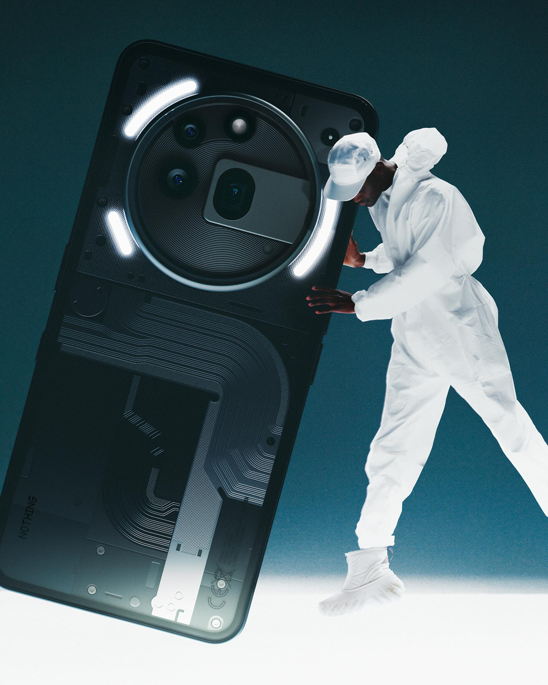 Person in Weiß hält ein Telefon mit transparentem Rücken, mit dunklem Hintergrund.