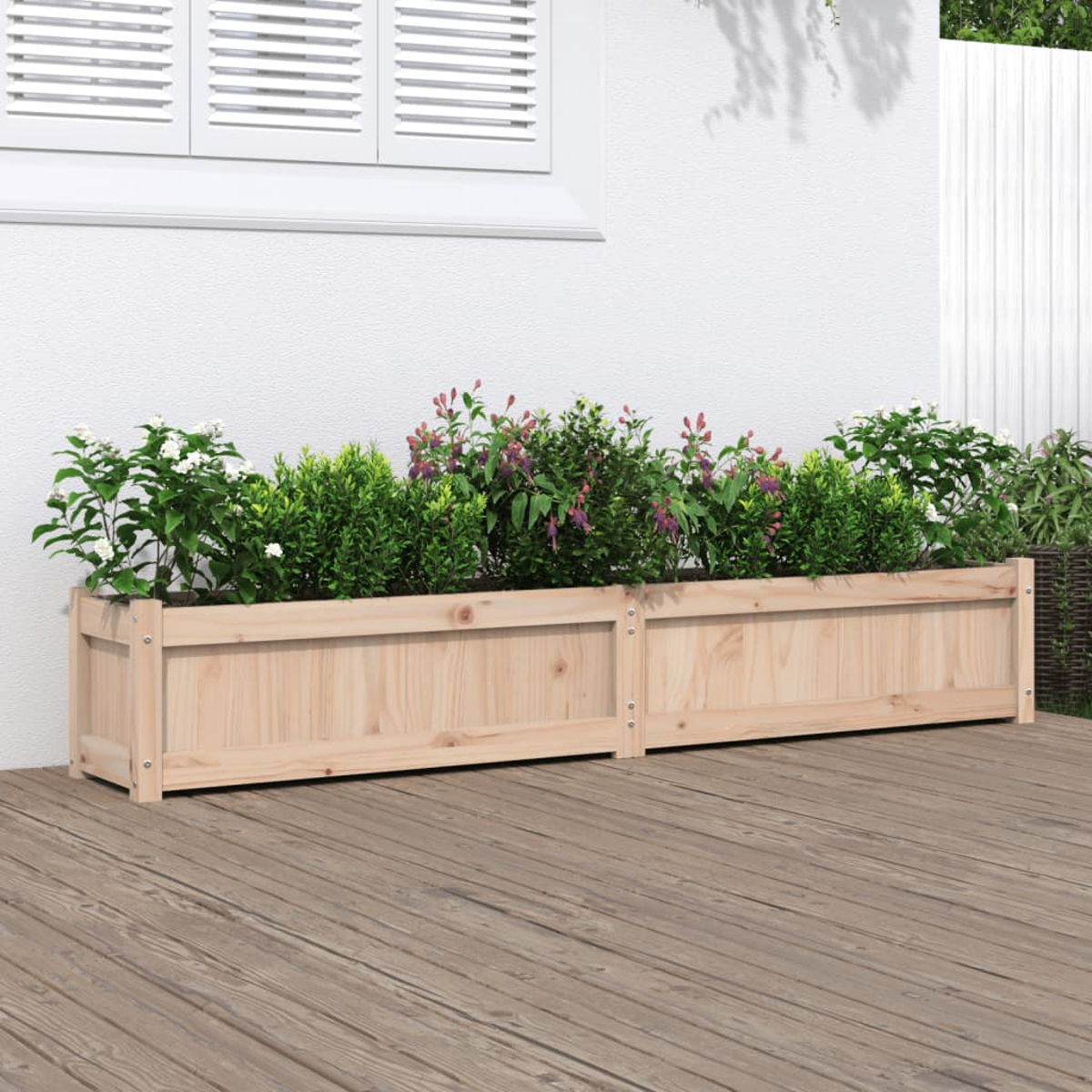 Blumenkästen aus Holz mit Pflanzen vor einer weißen Wand. Holzterrassendielen.