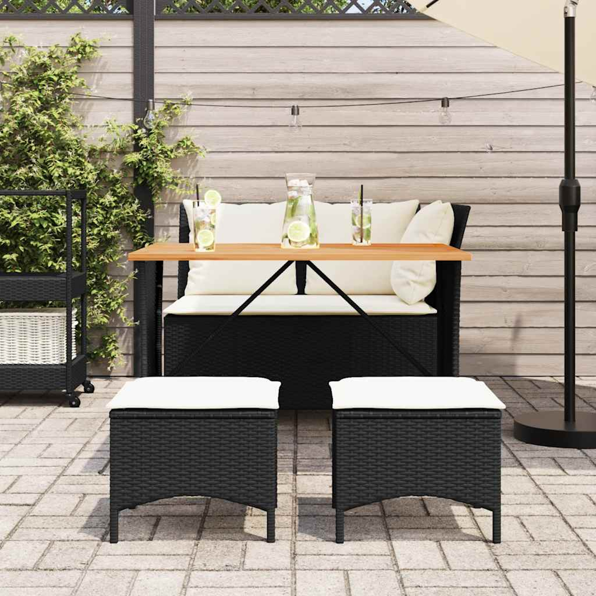 Un set da patio all'aperto con un tavolo, due pouf e un divano. Il set ha una struttura nera con cuscini bianchi.