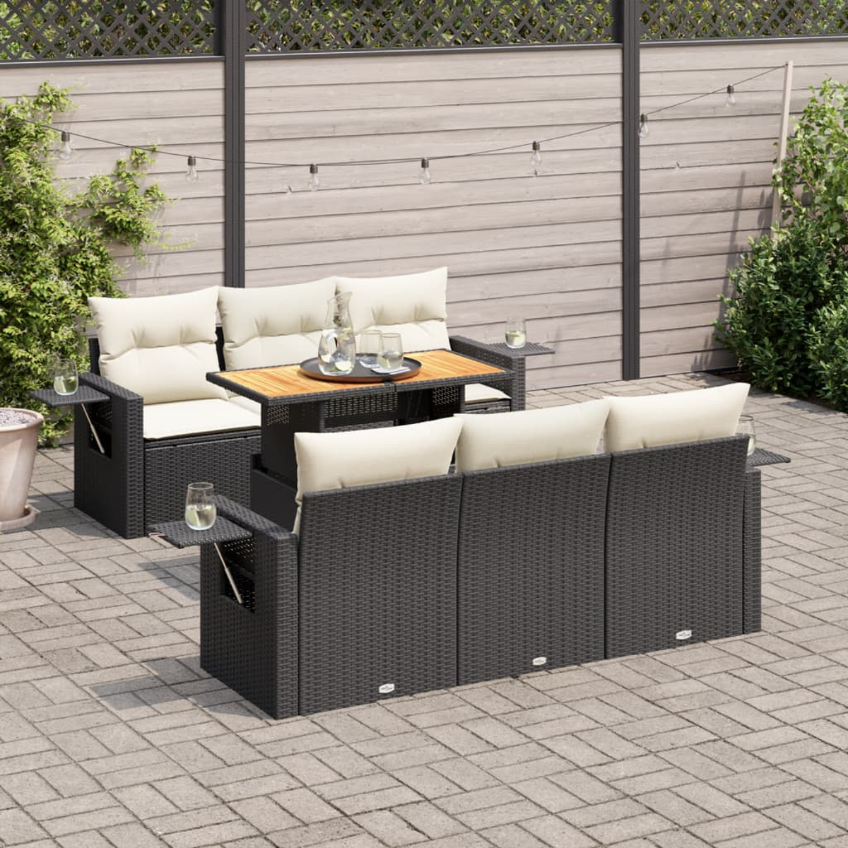 Set di sedute in rattan per esterni con tavolo e cuscini, su un patio.