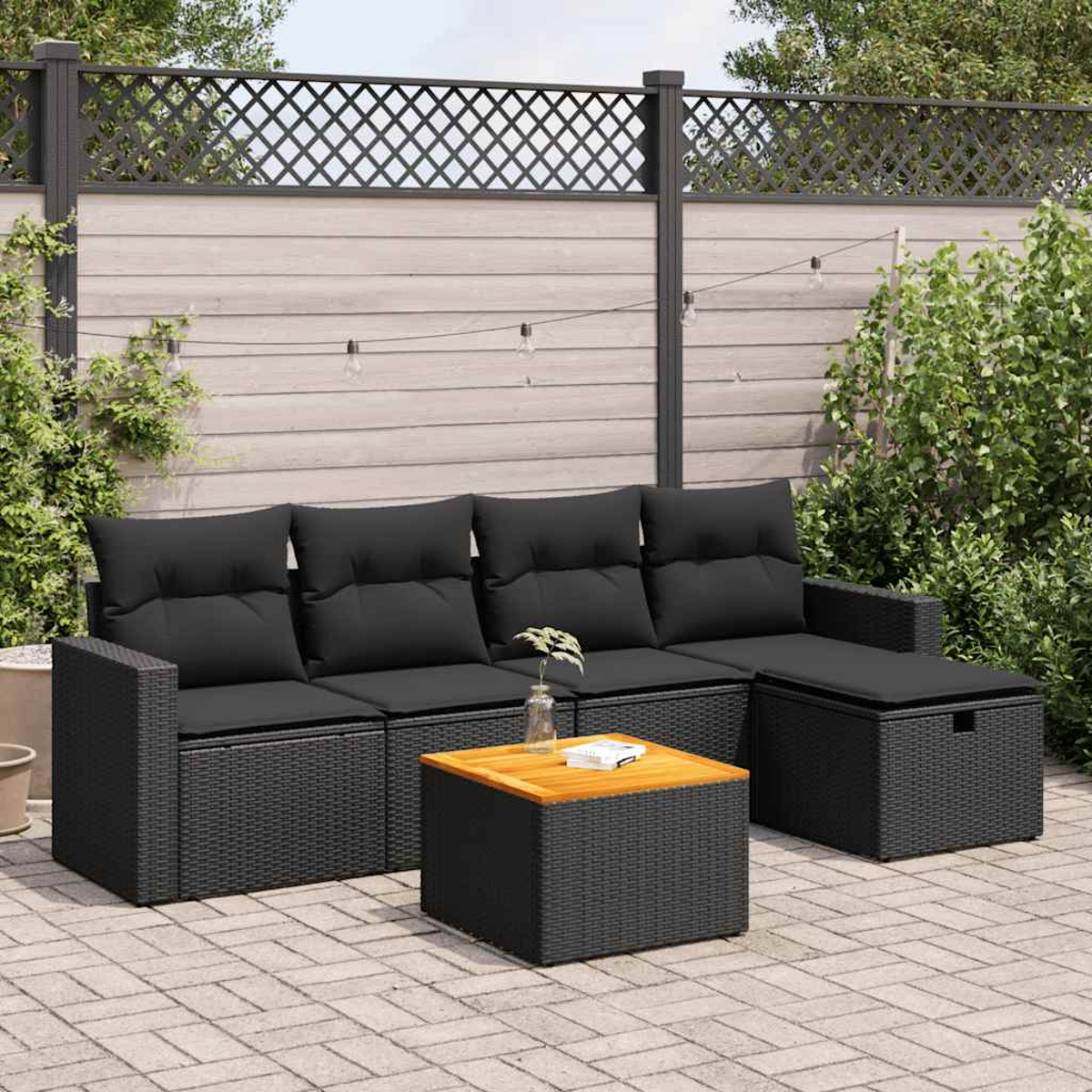 Schwarzes Outdoor-Möbelset aus Korbgeflecht mit schwarzen Kissen und einem Tisch mit Holzplatte.