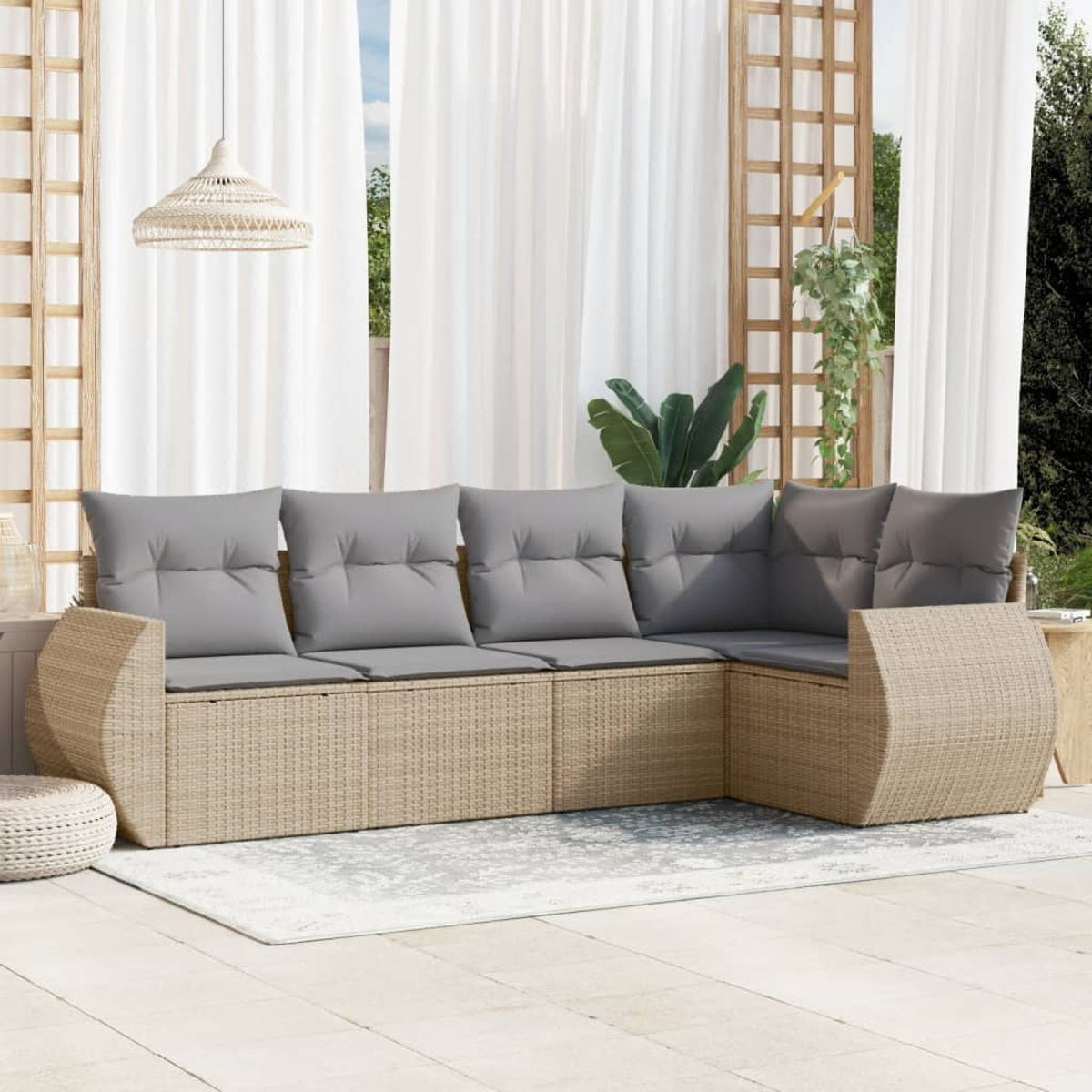 Outdoor-Ecksofa aus Korbgeflecht mit grauen Kissen auf einem Teppich.